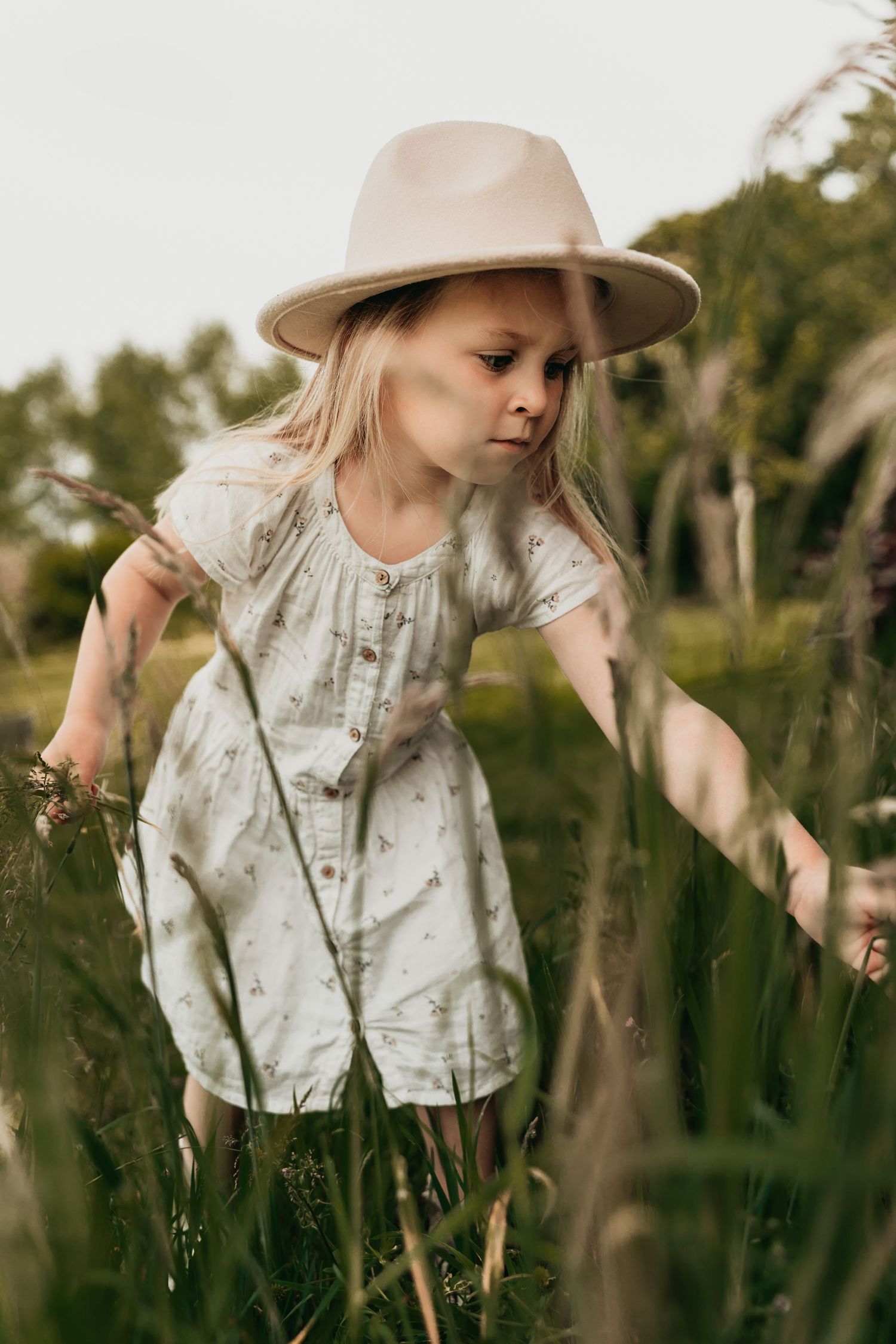 Een meisje op ontdekking tijdens een fotoshoot in het gras in Schijndel