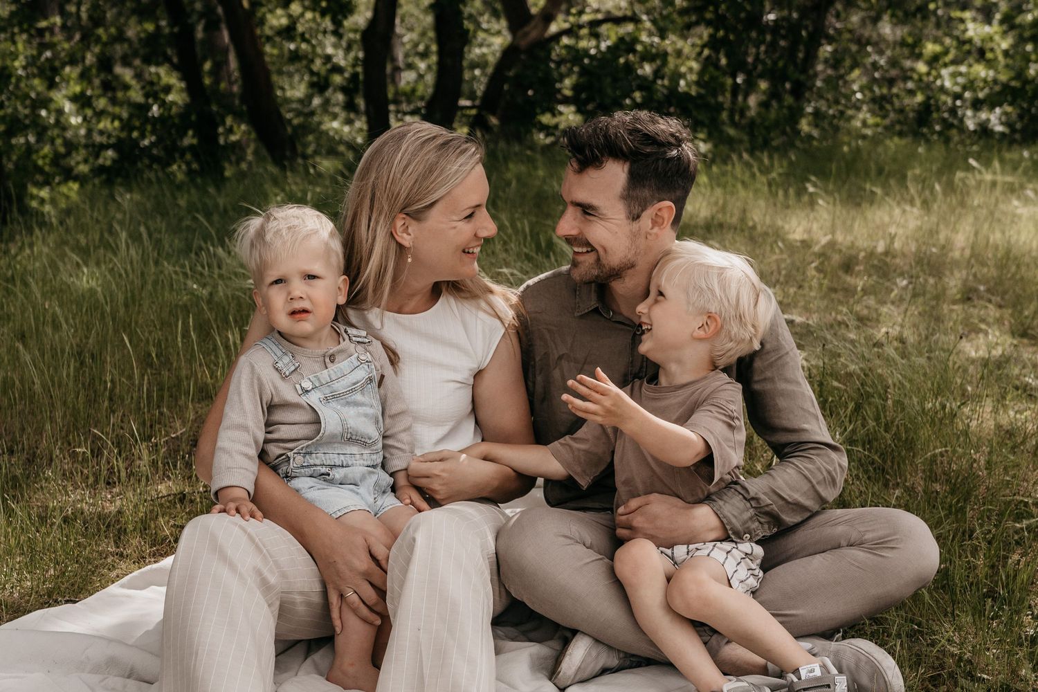 Spontane familiefoto van een gezin zittend in het gras in Breda
