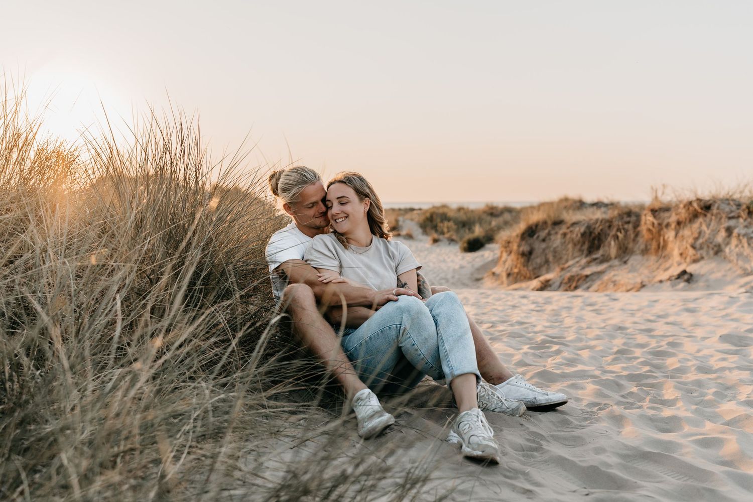 Foto aan zee in de duinen van een gelukkig koppel