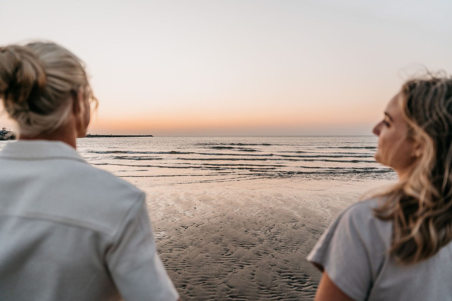 Koppel tijdens een coupleshoot op het strand met zonsondergang
