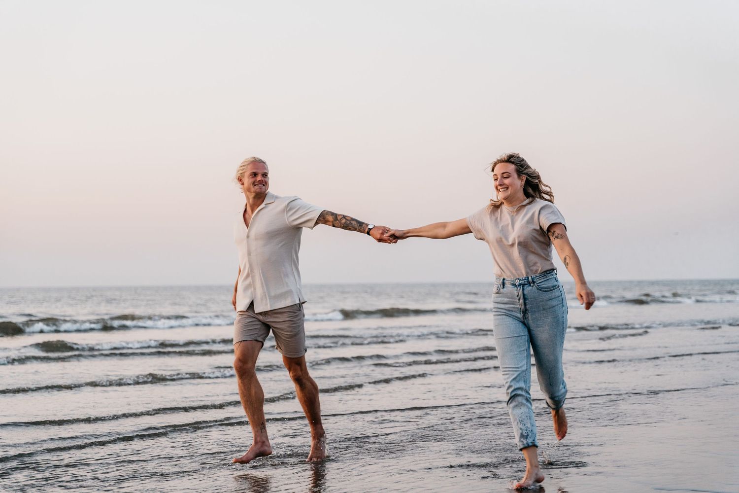 Hand in hand op het strand tijdens het gouden uur