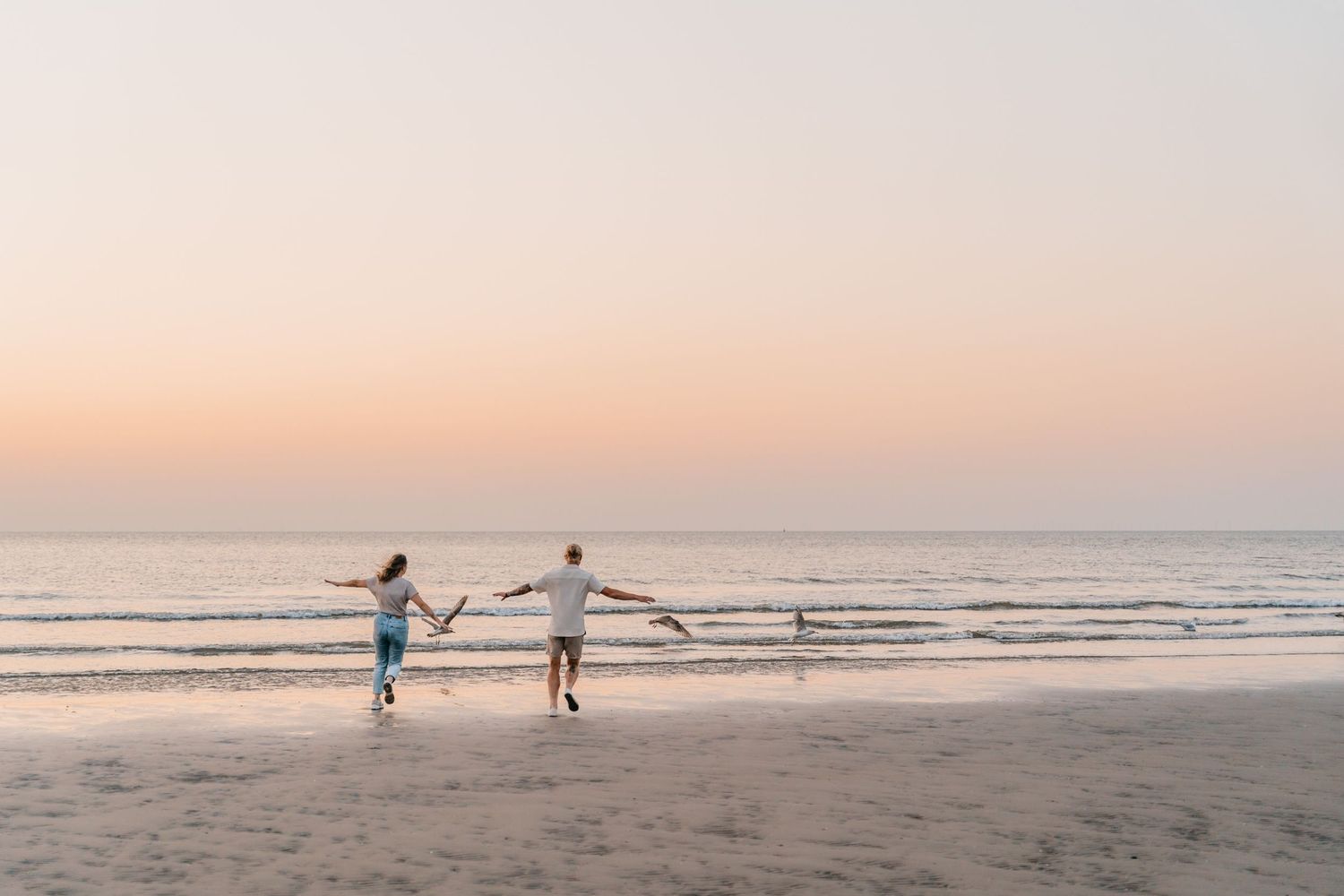 Couple in love chasing the sun at the beach