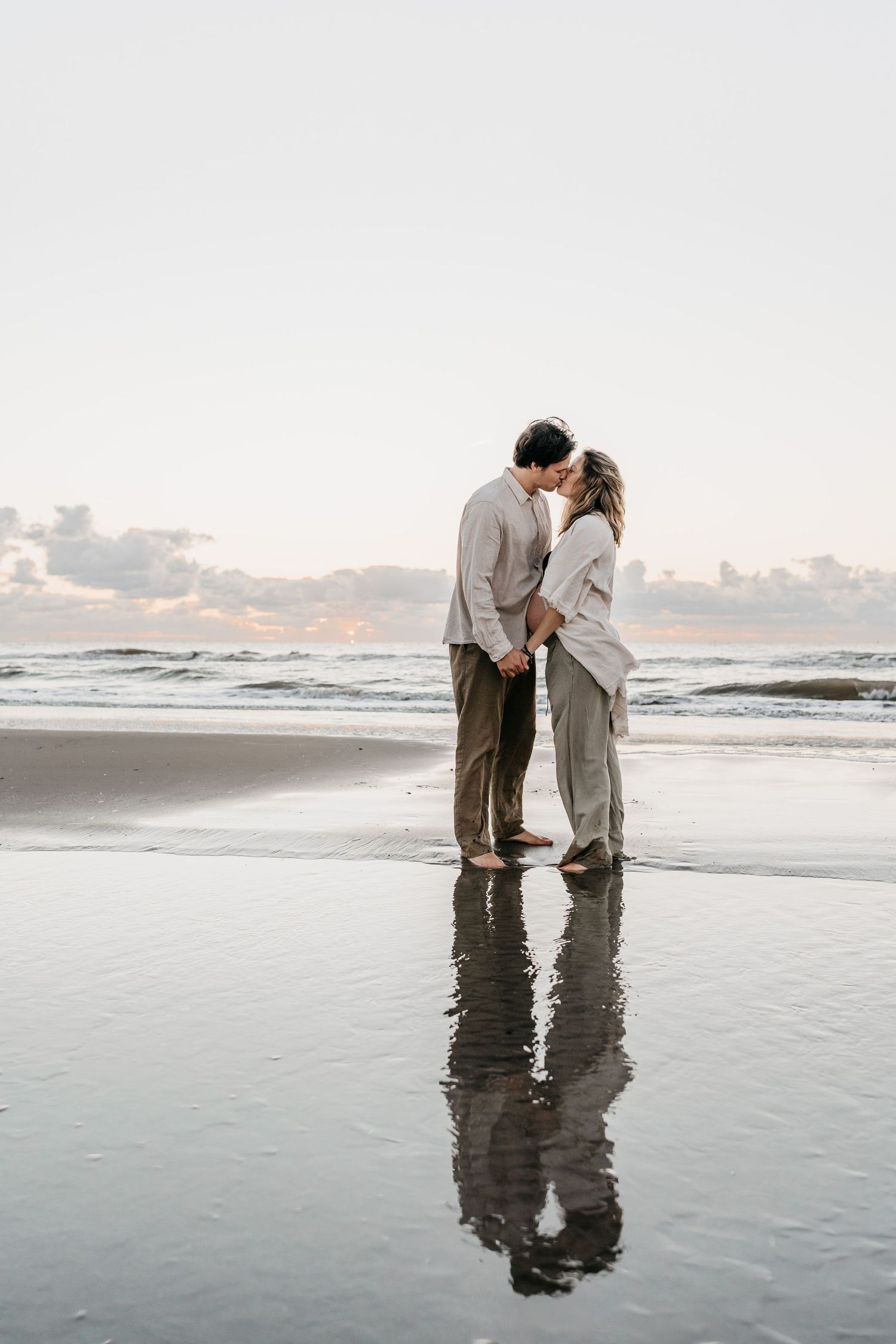 Reflecting maternity photo at the beach during sunset