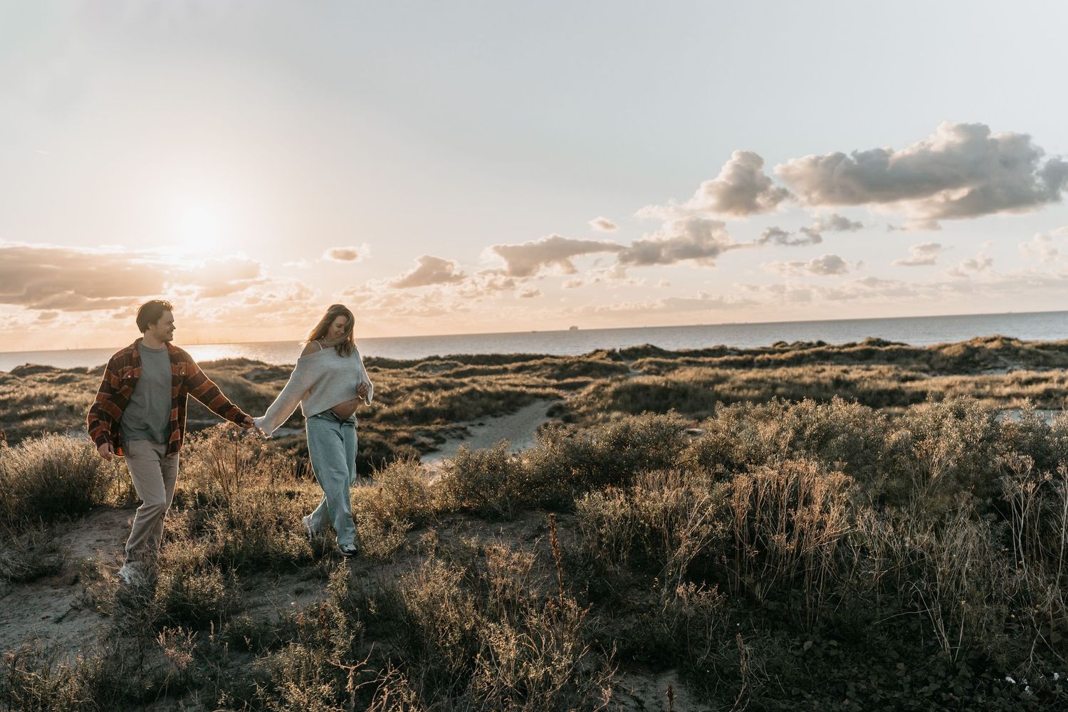 Zwangerschapsshoot in de duinen met de zee op de achtergrond