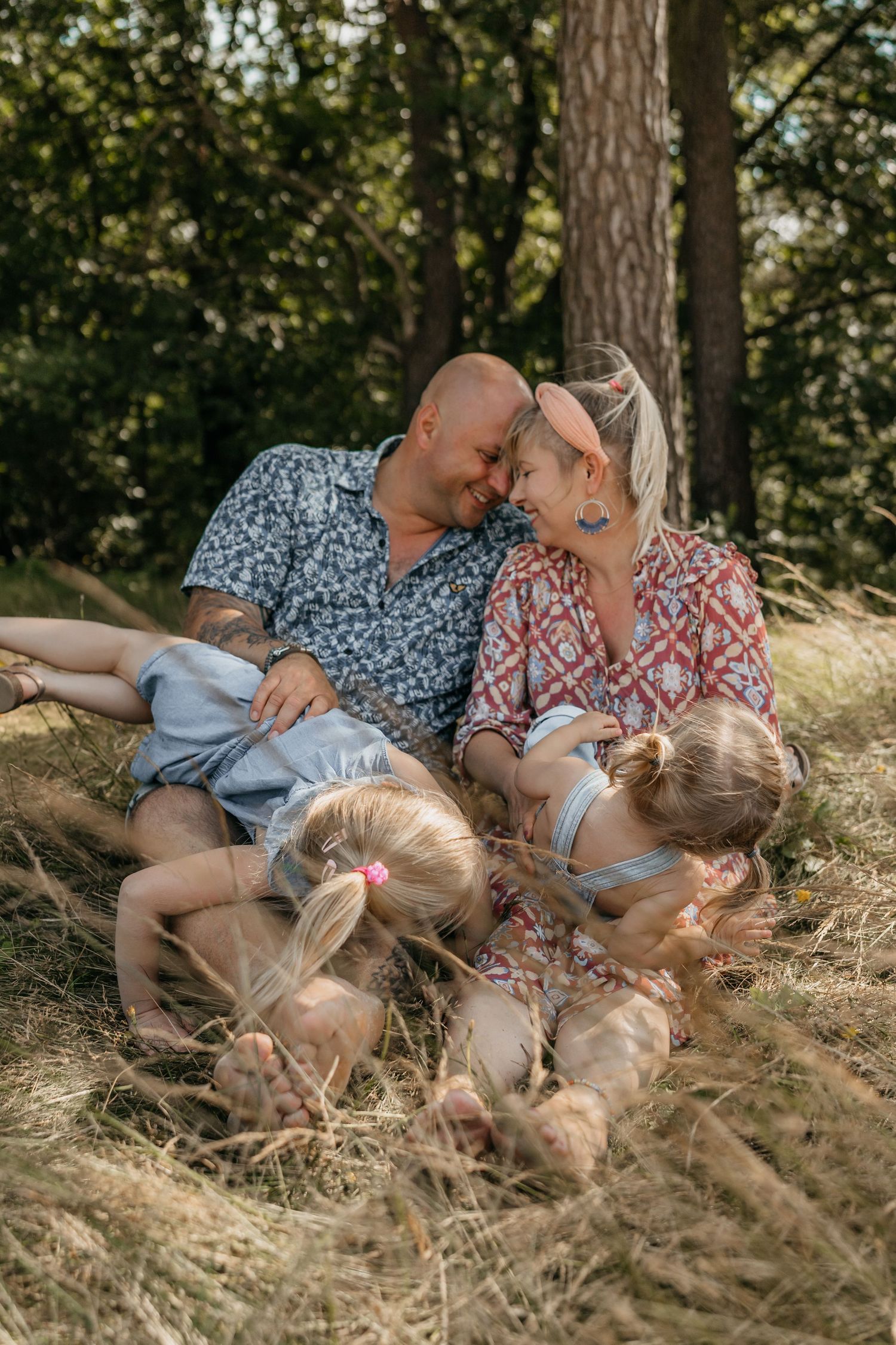 Warme familiefoto van een gelukkig gezin dat speelt in het gras.