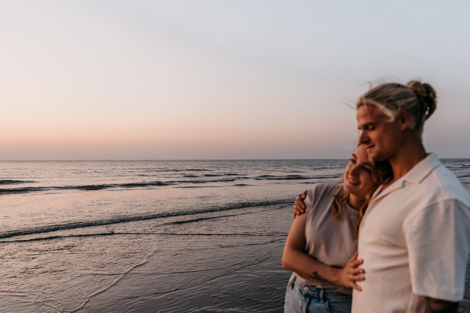 Verliefd koppel op het strand tijdens goldenhour