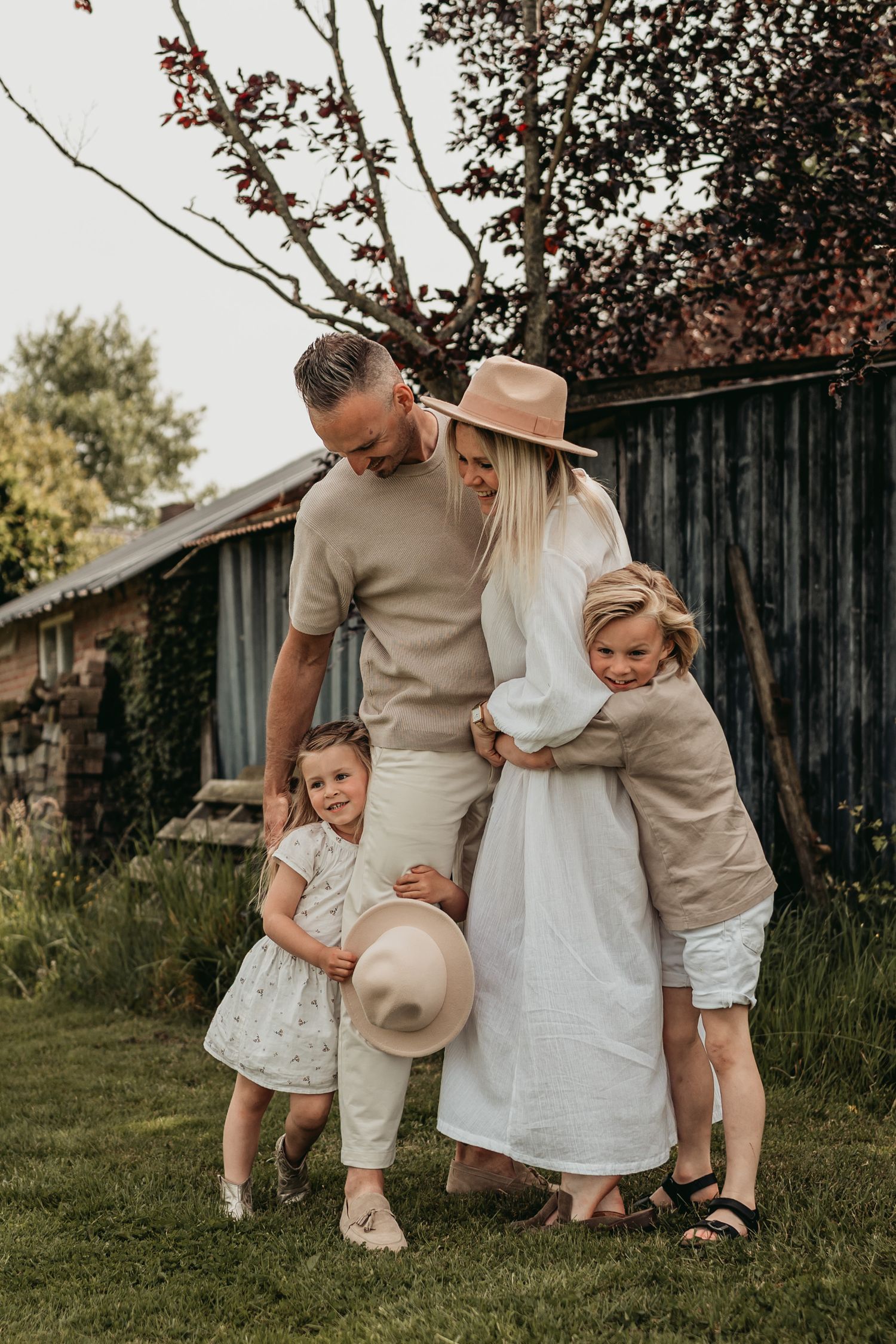 Een familie knuffelt elkaar tijdens een spontane fotoshoot op een boerderij in Noord-Brabant