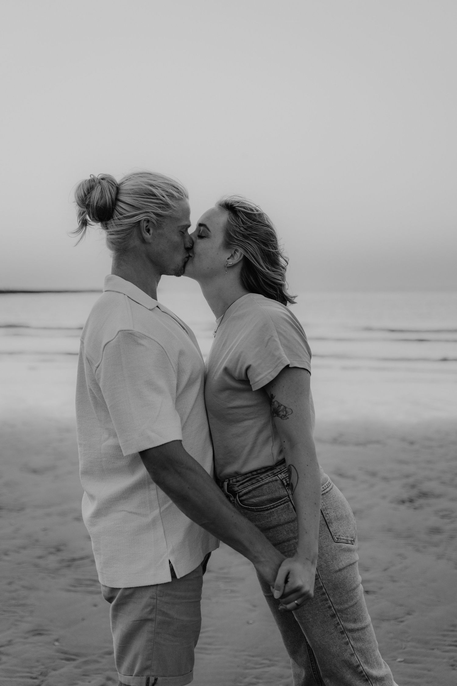 Zwart-wit foto van een avontuurlijk koppel op het strand