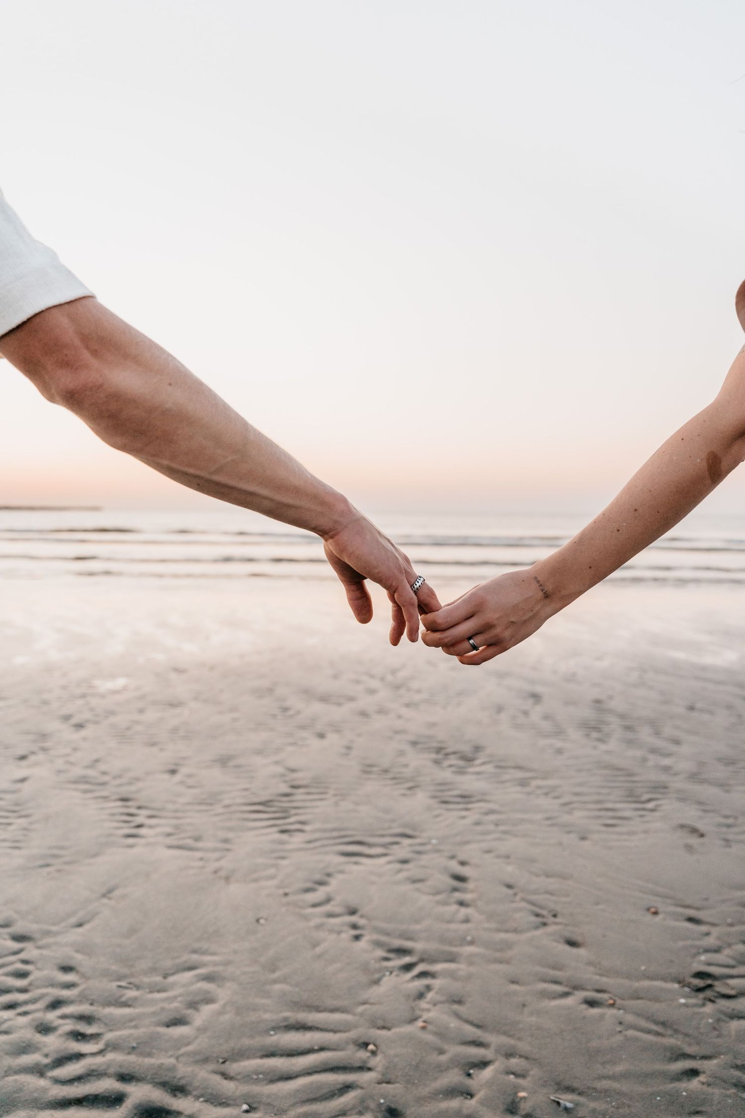 Detailshot of hands touching during couple shoot at the beach