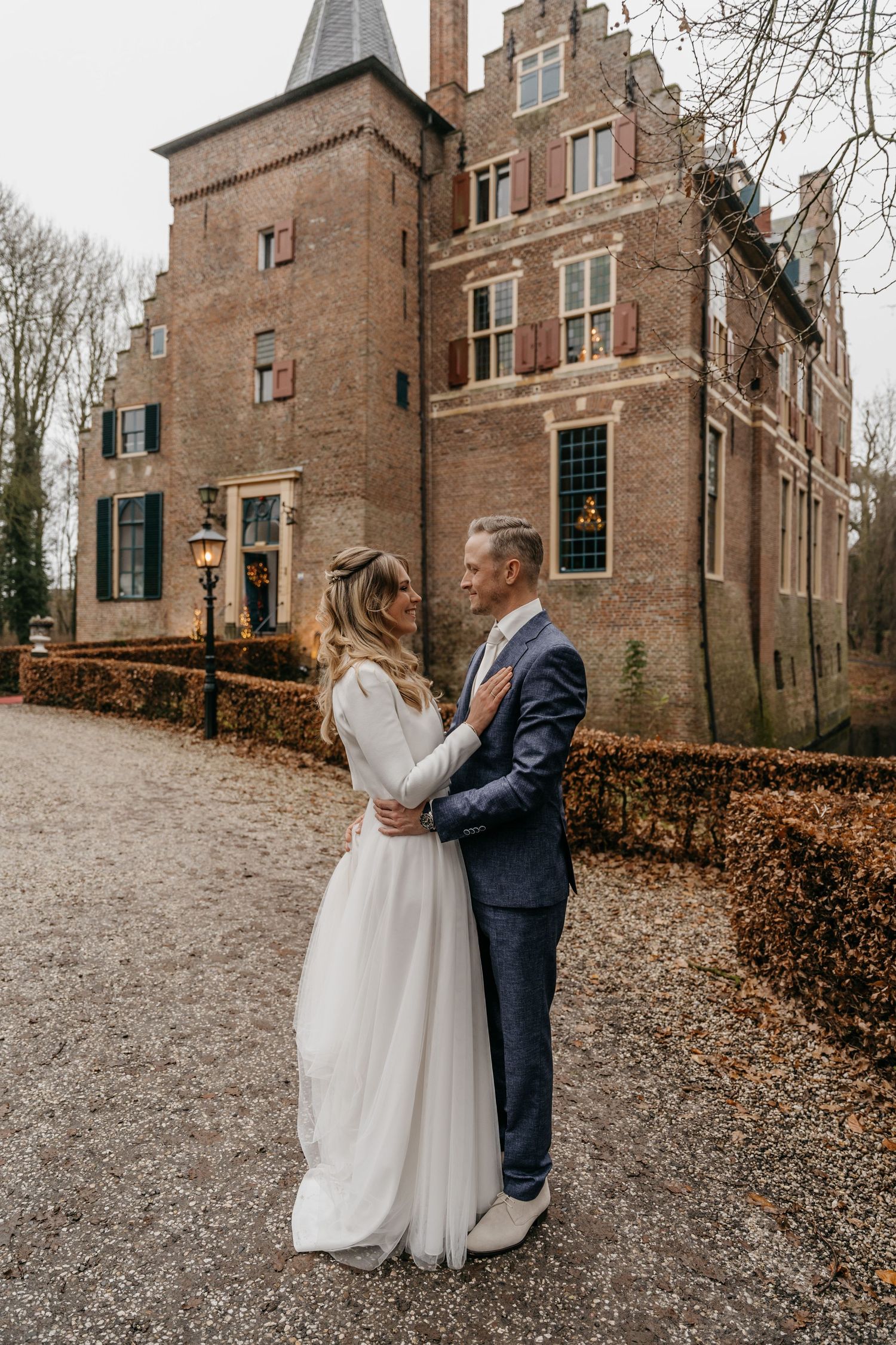 Bruidspaar voor Kasteel Wijenburg tijdens bruiloft