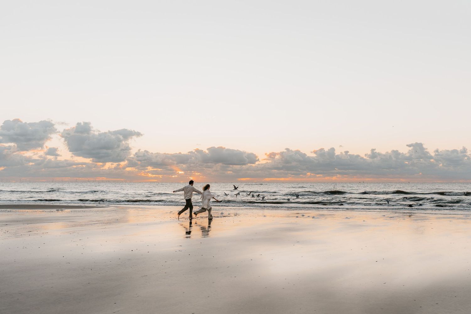 Avontuurlijk koppel tijdens zonsondergang aan het strand