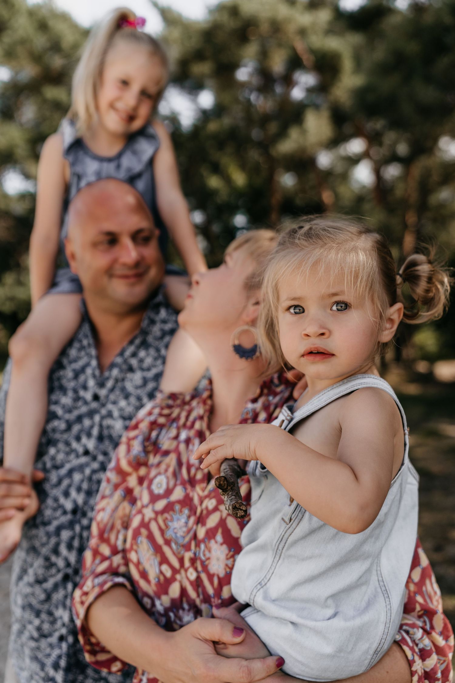 Ouders tillen lachend de kinderen op tijdens een fotoshoot in het bos in Brabant