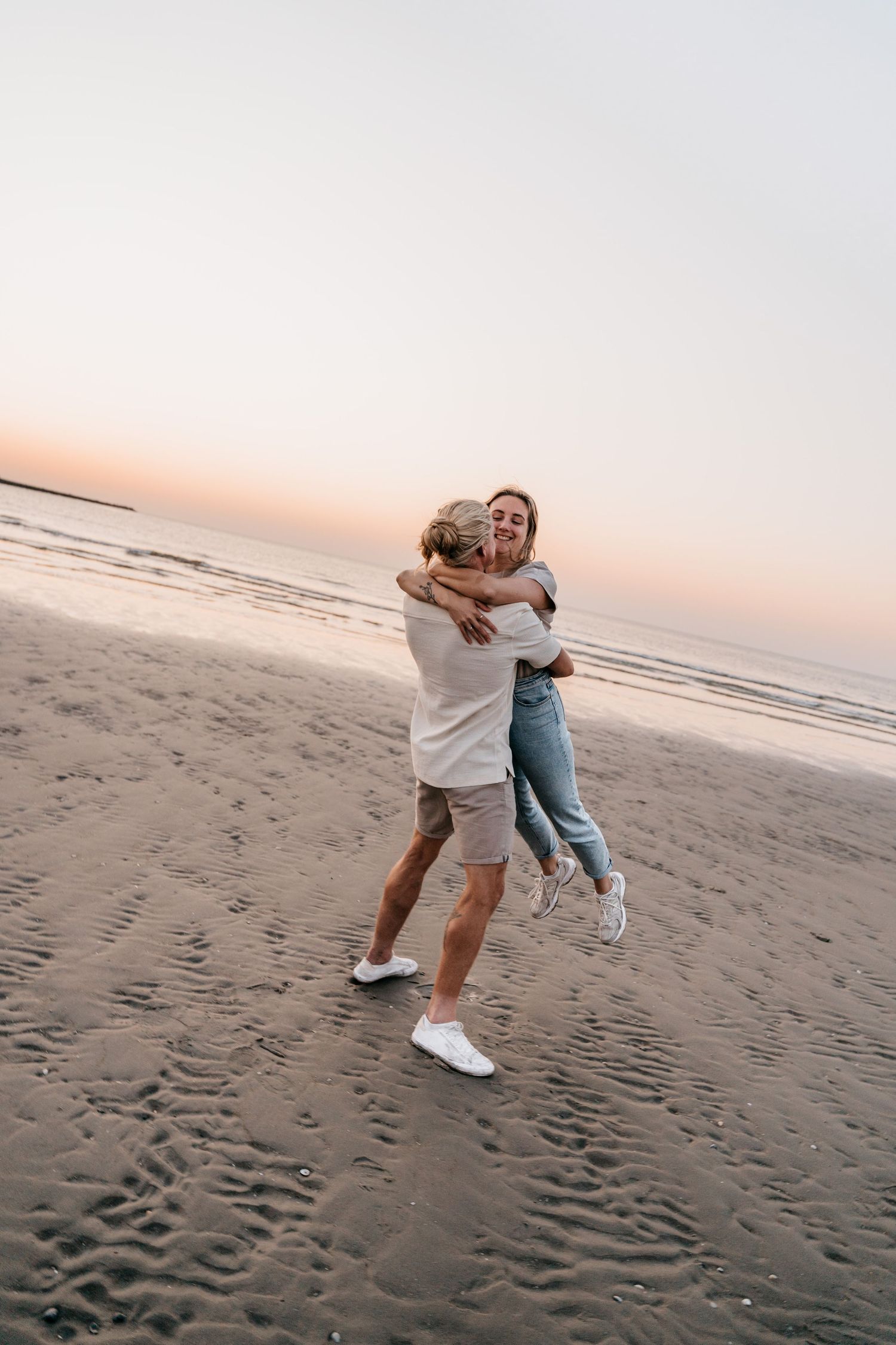 Couple in love during photoshoot at the beach at sunset