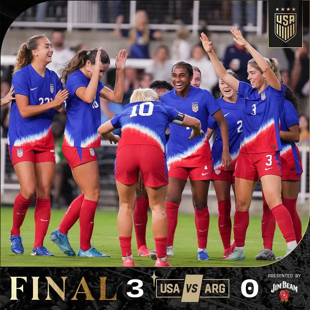 US Women's soccer team celebrating after scoring during a match.