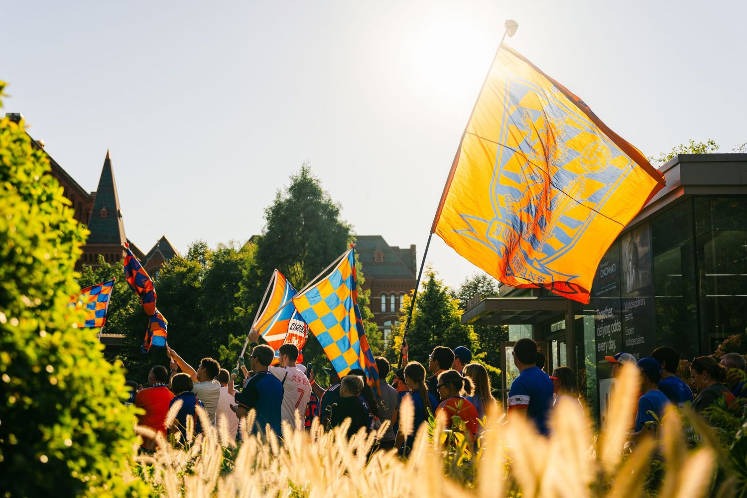 Yellow and orange flags waving in golden sunset light against residential buildings. (Photo by Chris Carter/Getty Images/Stringer)