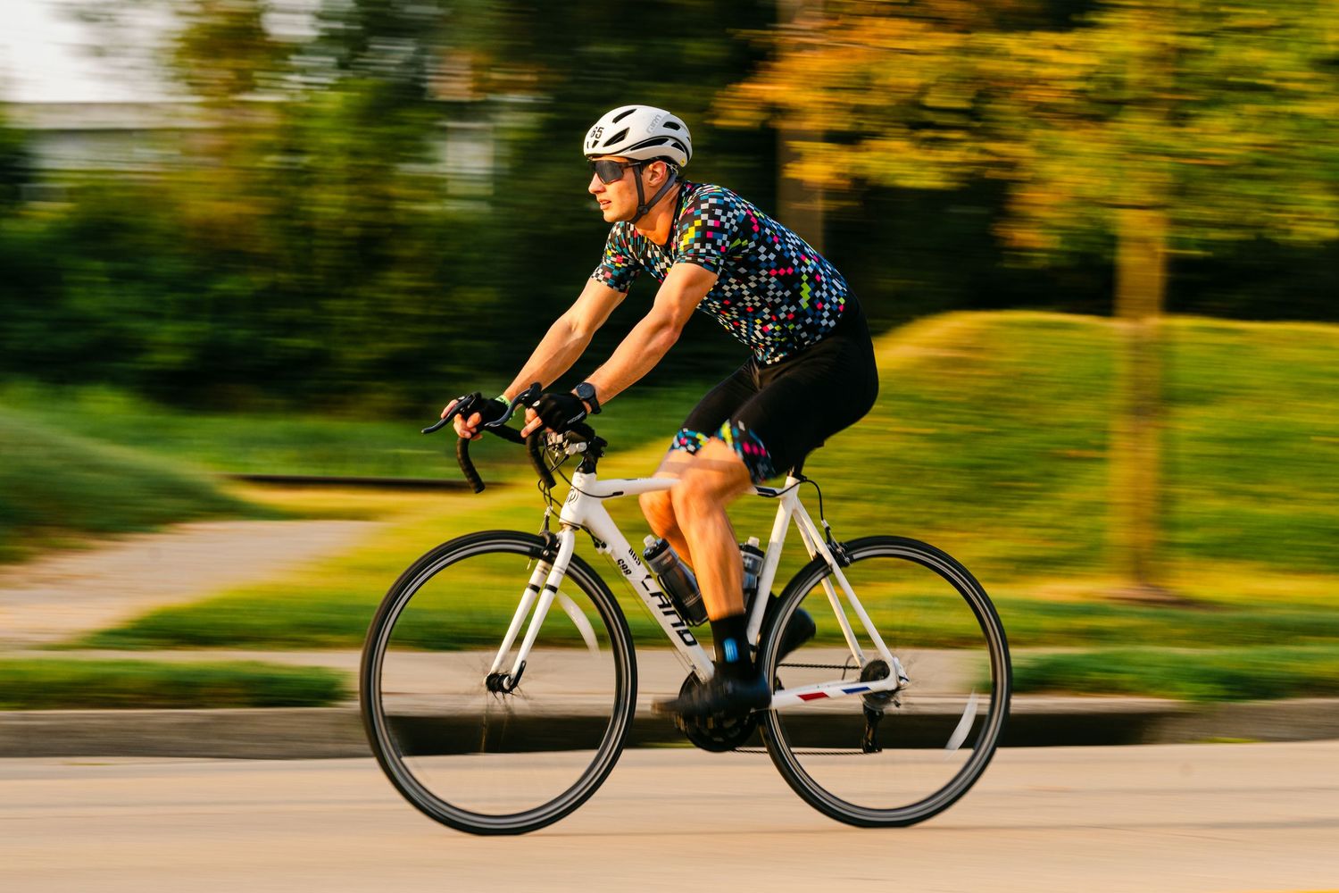Motion-blurred cyclist riding on a path with autumn colors in the background.