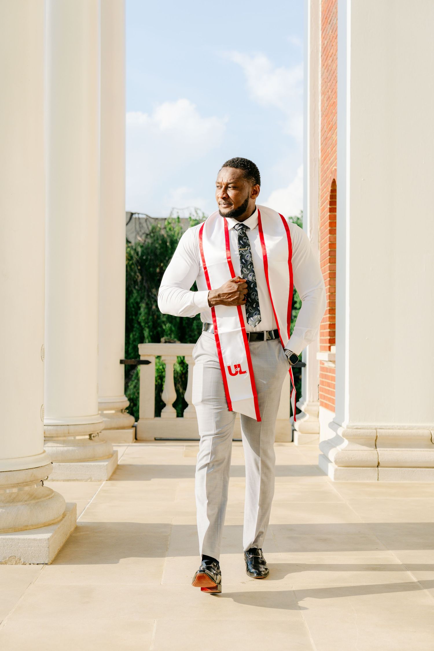 Elegant walking sequence along a classical columned arcade in formal attire.
