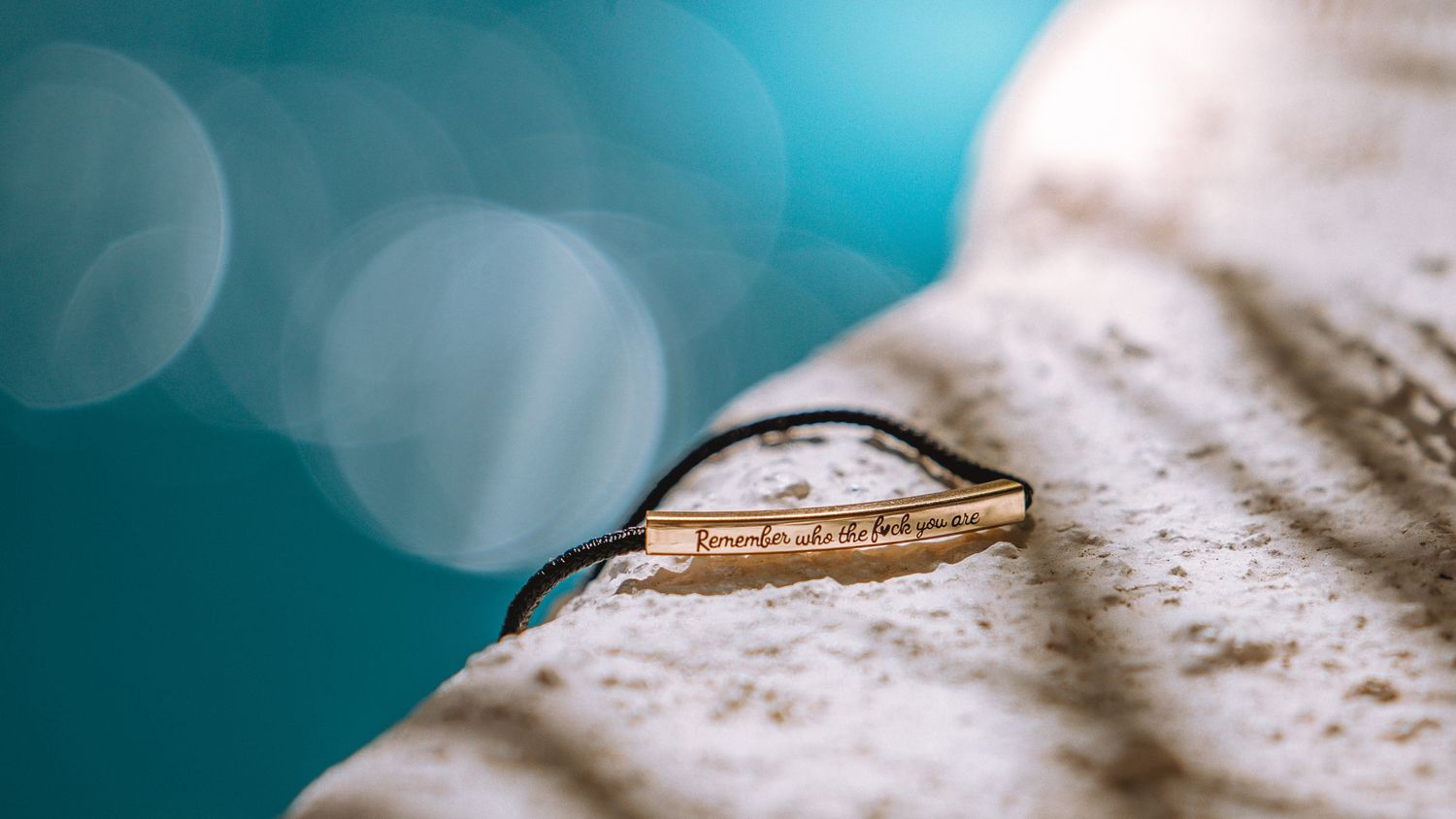 Wedding ring macro photography with turquoise bokeh background.