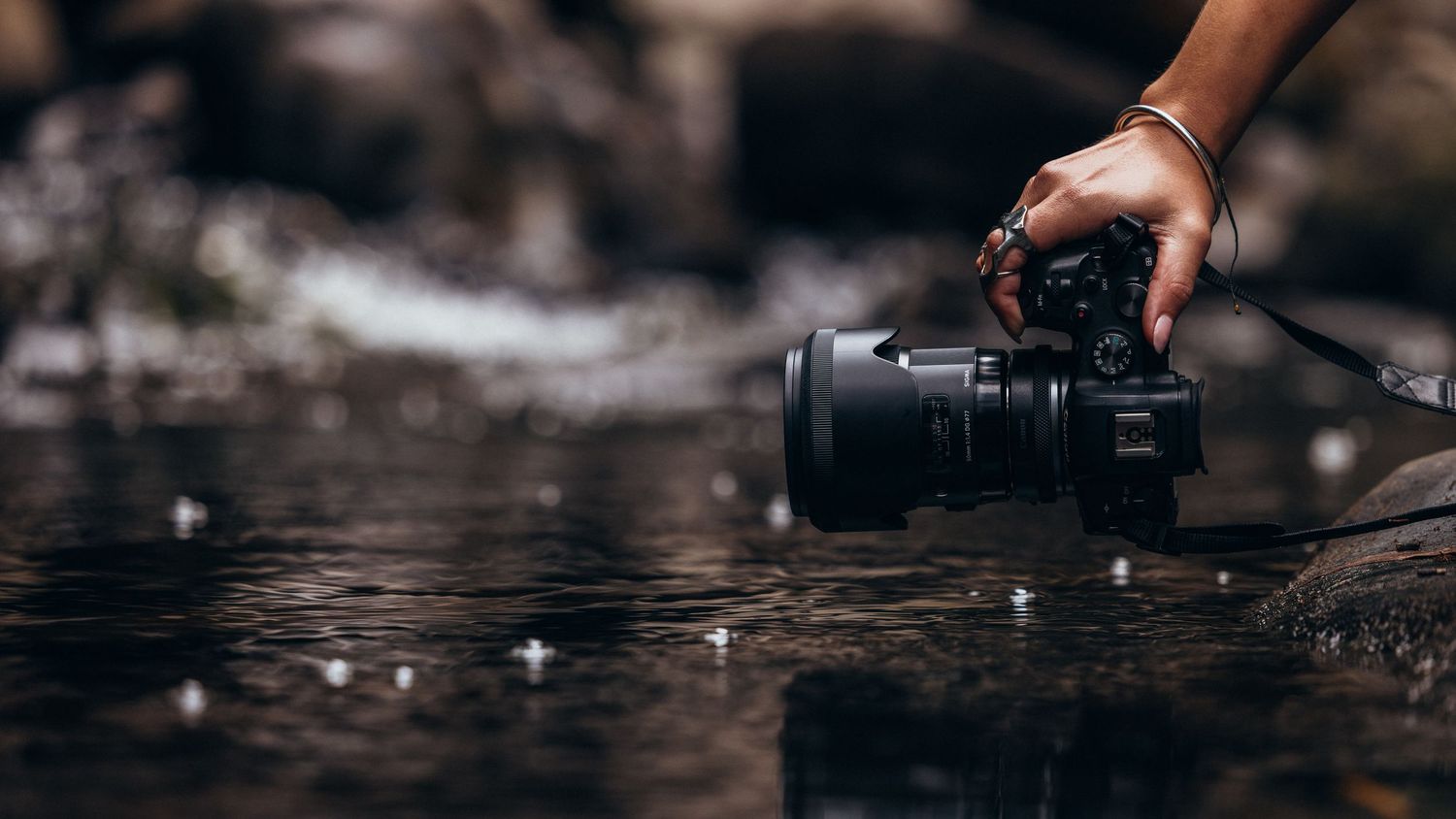 Close-up shots of camera equipment arranged in a dark moody setting.