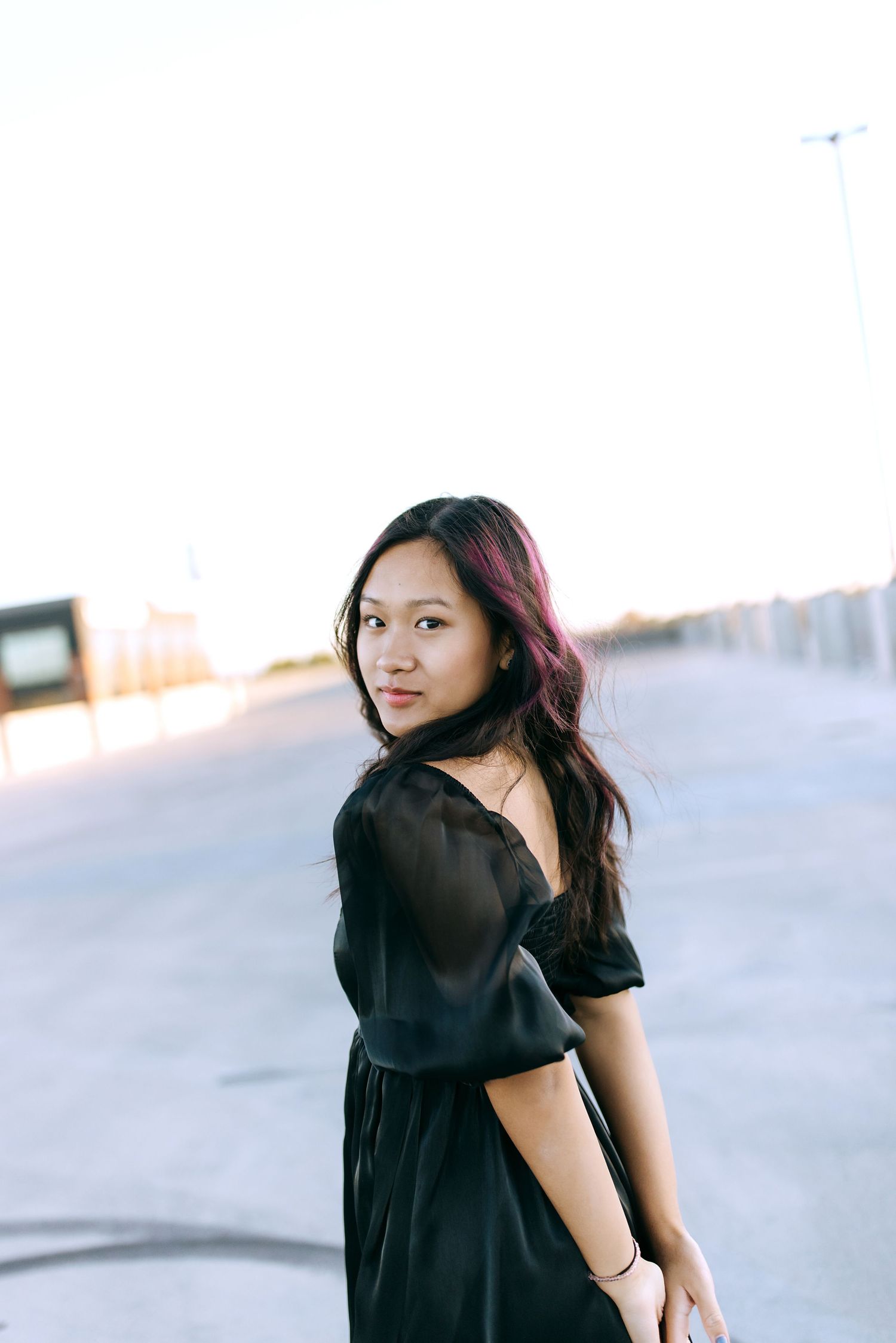 A person in a black top poses confidently against a light background in a series of casual portrait shots.