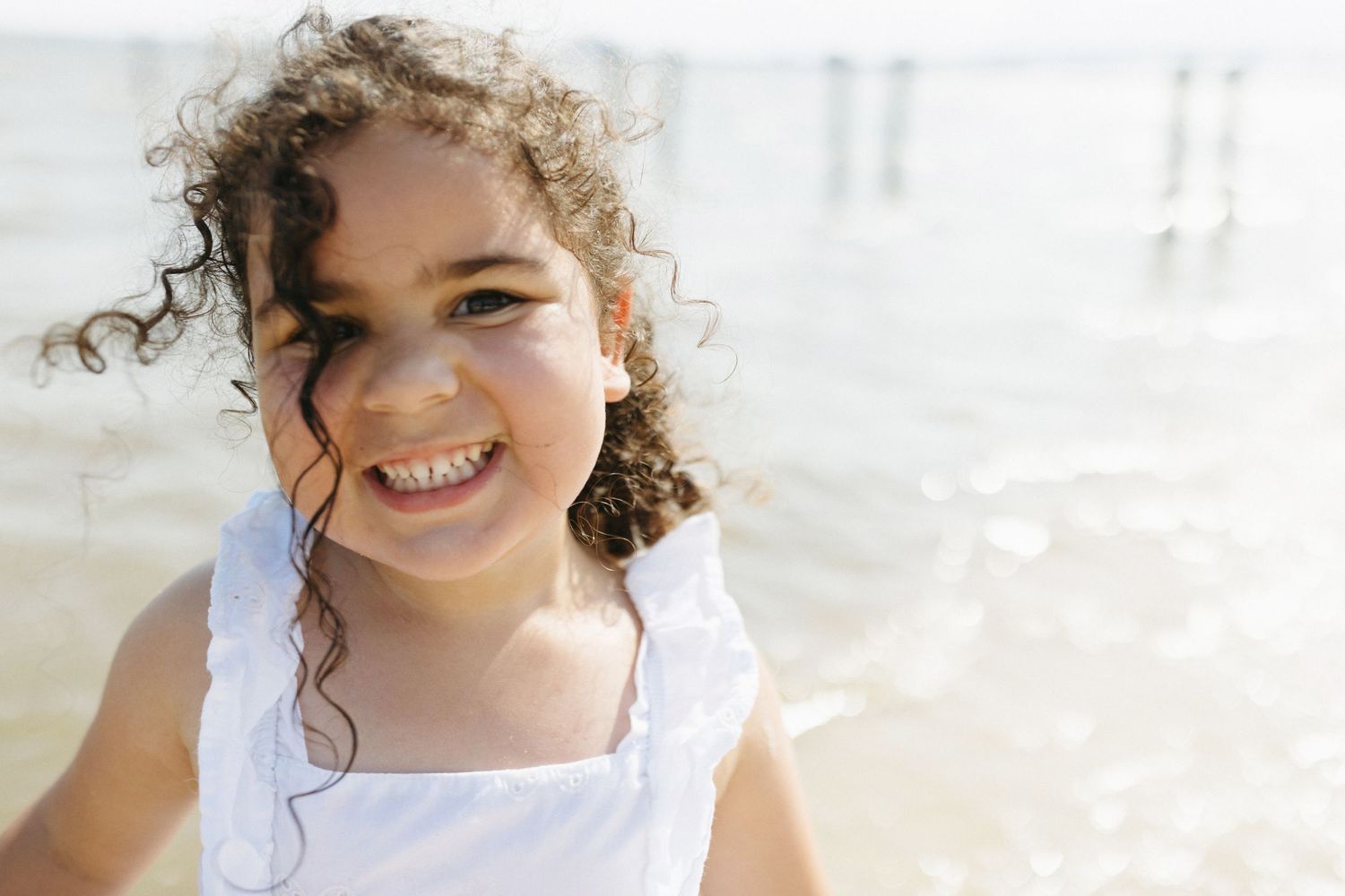 A bright series of candid shots showing someone's expressions and curly hair against a light background.