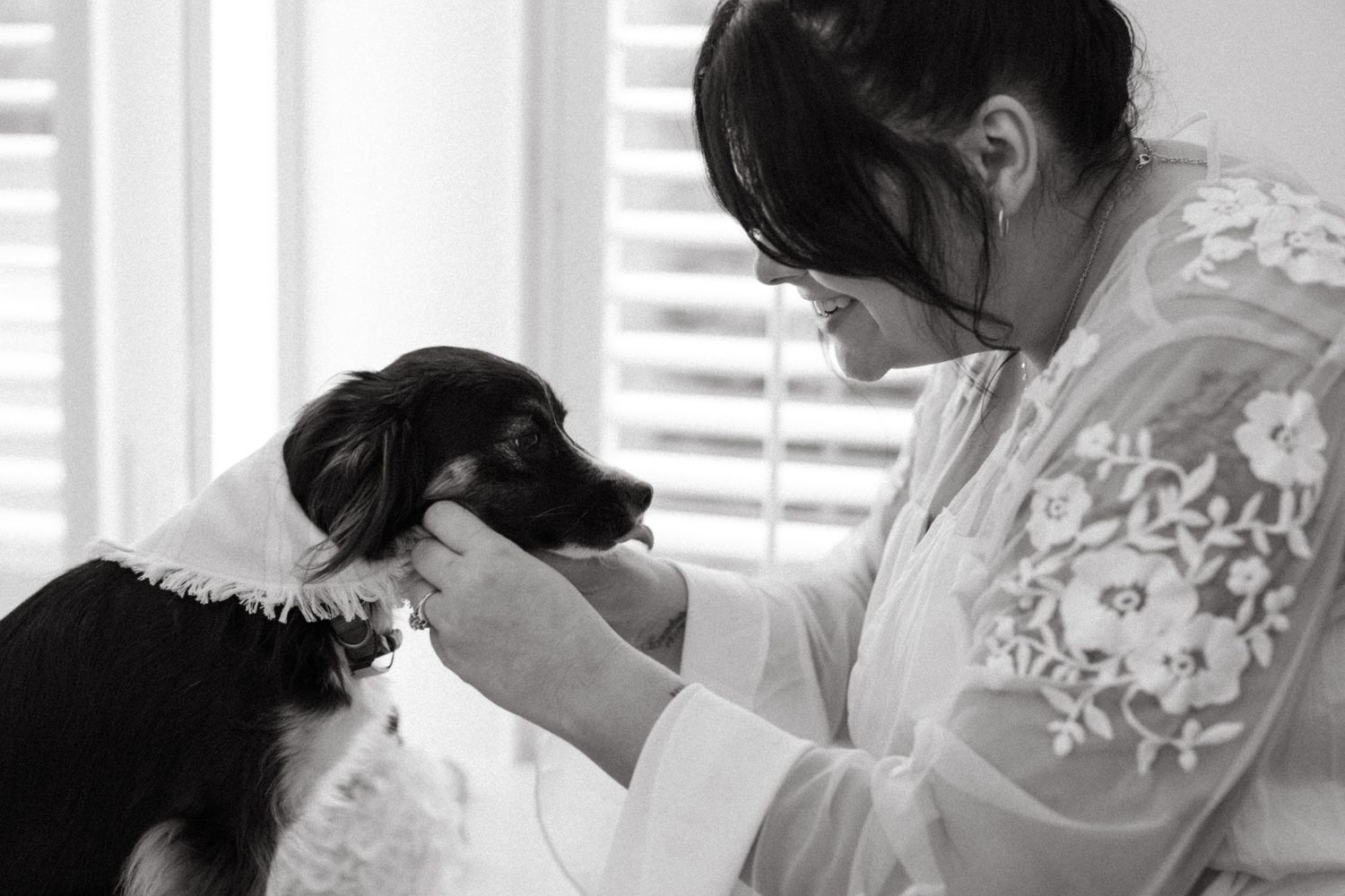 Close-up details of delicate lace wedding dress being fastened in morning preparation.