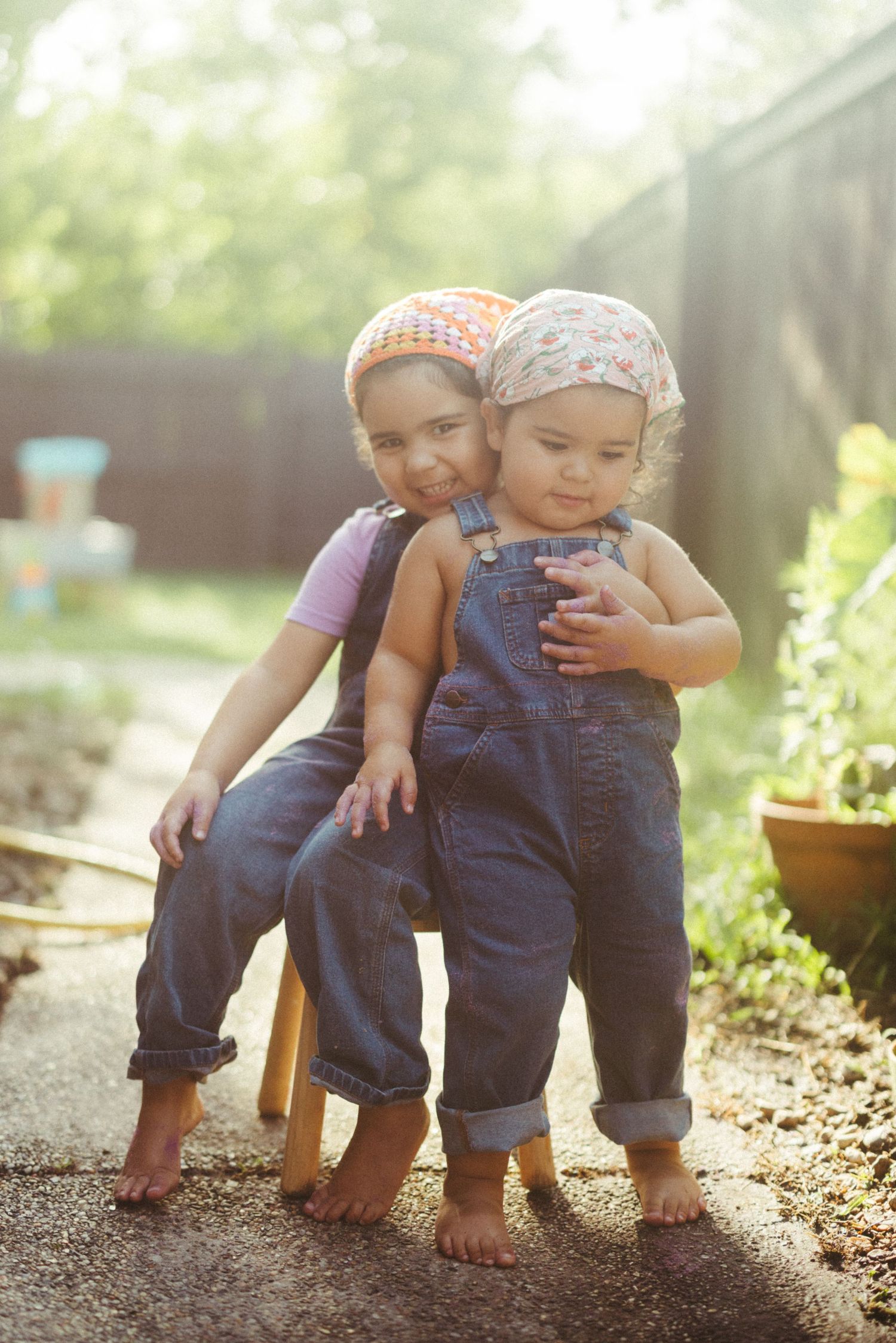 A series of candid photographs showing little feet and denim overalls walking through sunny garden dirt.