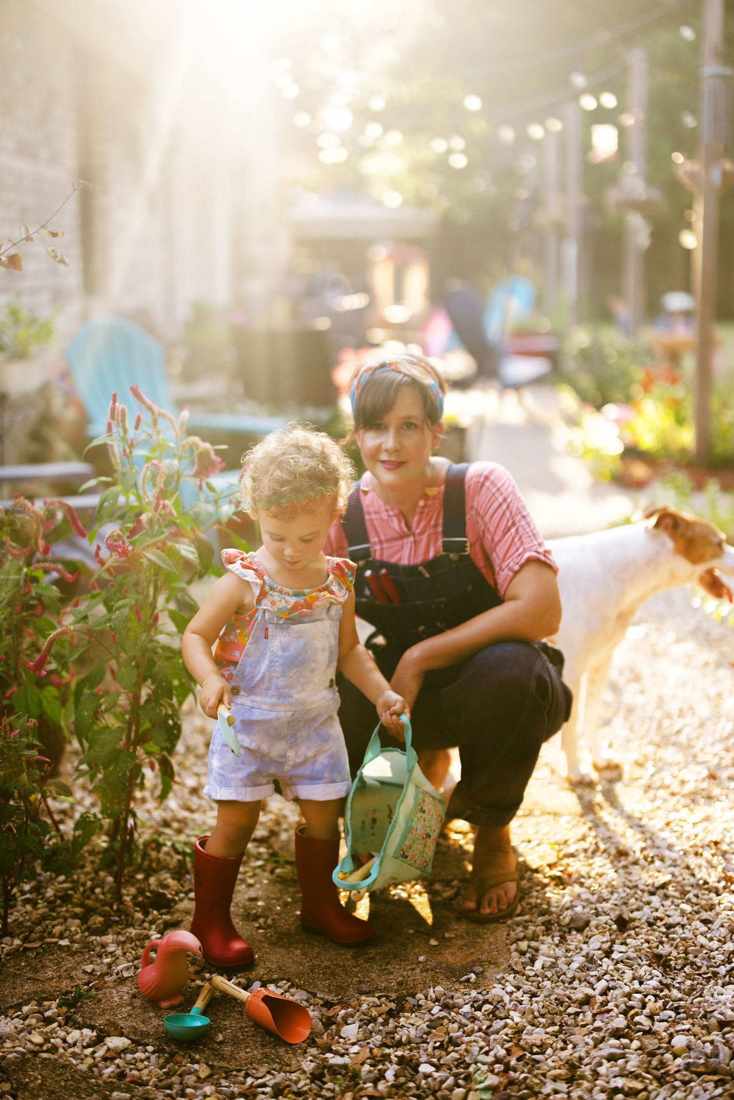 Playful moments captured in a garden with mulch and plants during sunset lighting.