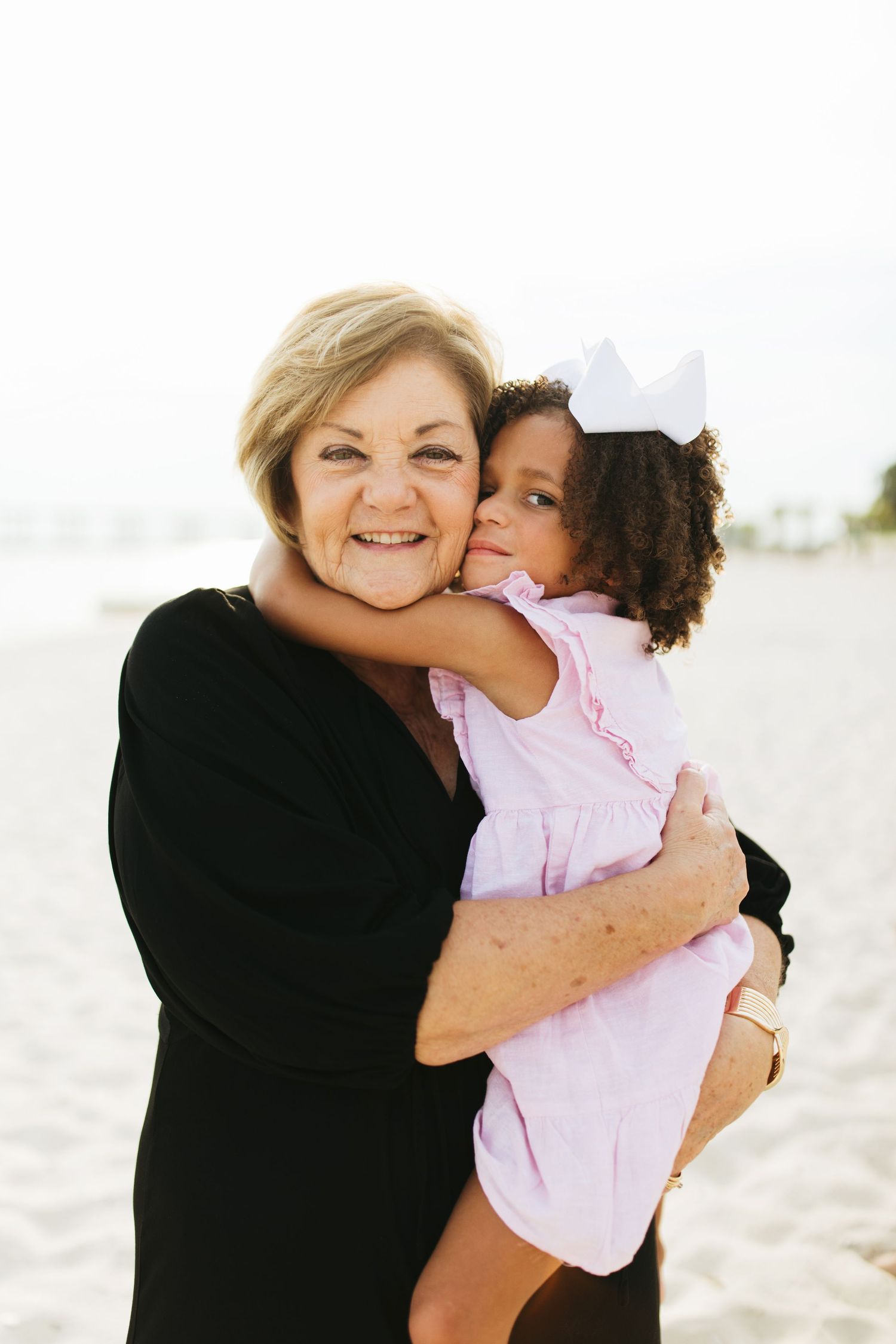 Heartwarming embraces between family members during beachside photoshoot.