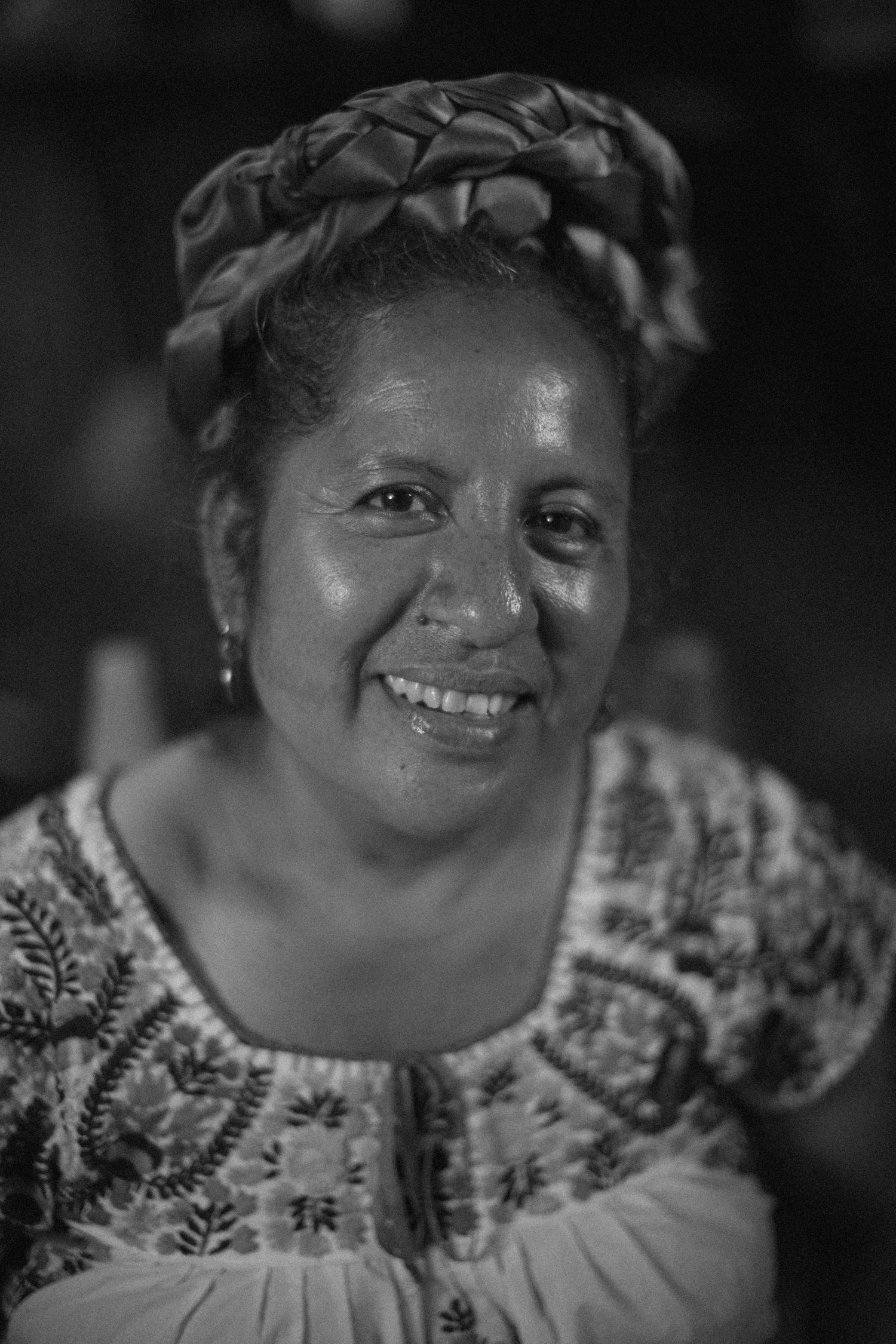 Black and white portraits show a smiling figure wearing an embroidered top with floral patterns.