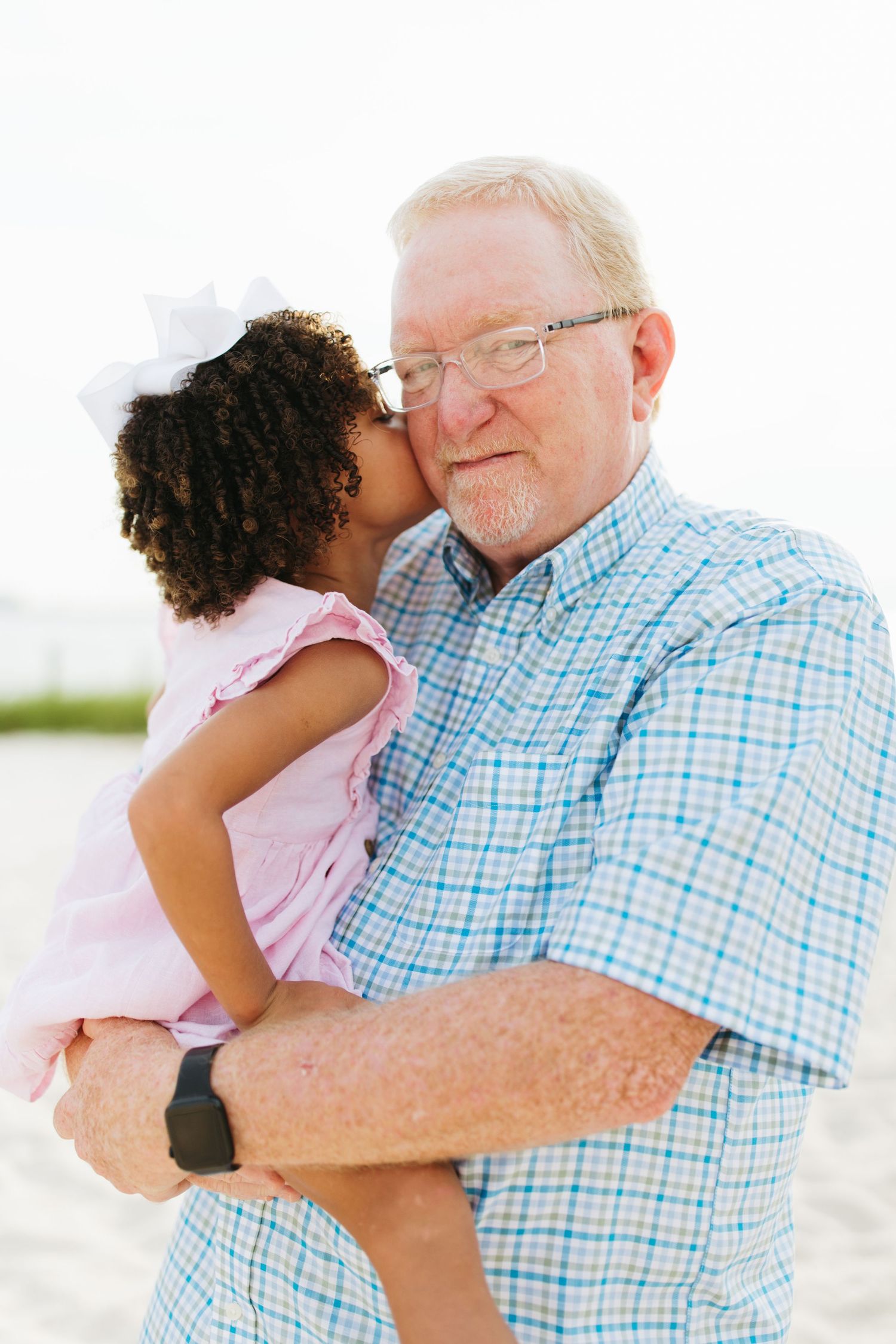 Sweet intergenerational moment of gentle embraces on a sunny beach.