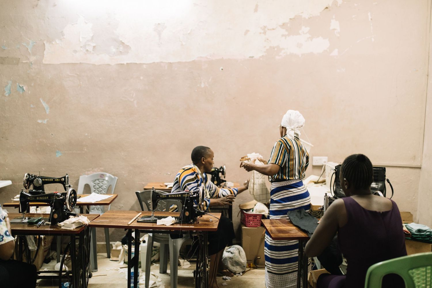 Students sit at desks in a classroom while a teacher stands at the front giving instruction during a lesson.