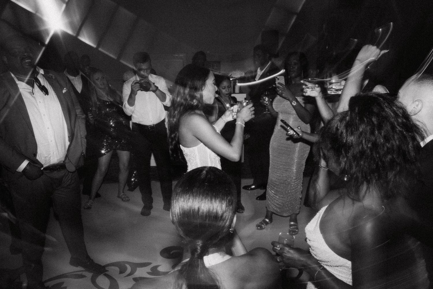 People dancing and moving energetically together at what appears to be a concert or dance party.