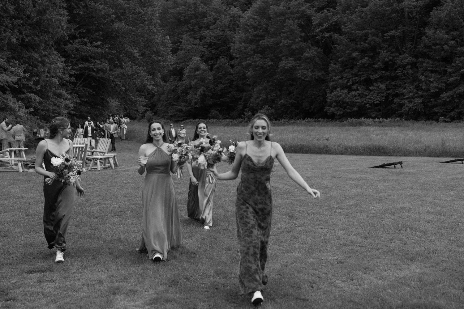 A group of people enjoying outdoor festivities and activities on a grassy field during a sunny summer day.
