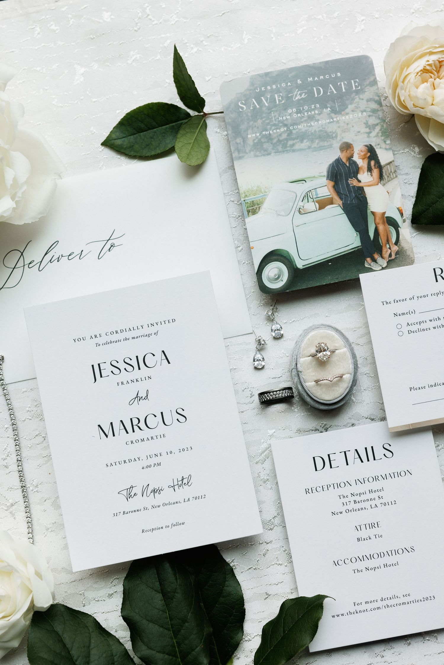 Elegant wedding invitation suite with vintage car save-the-date photo and white floral details on marble background.