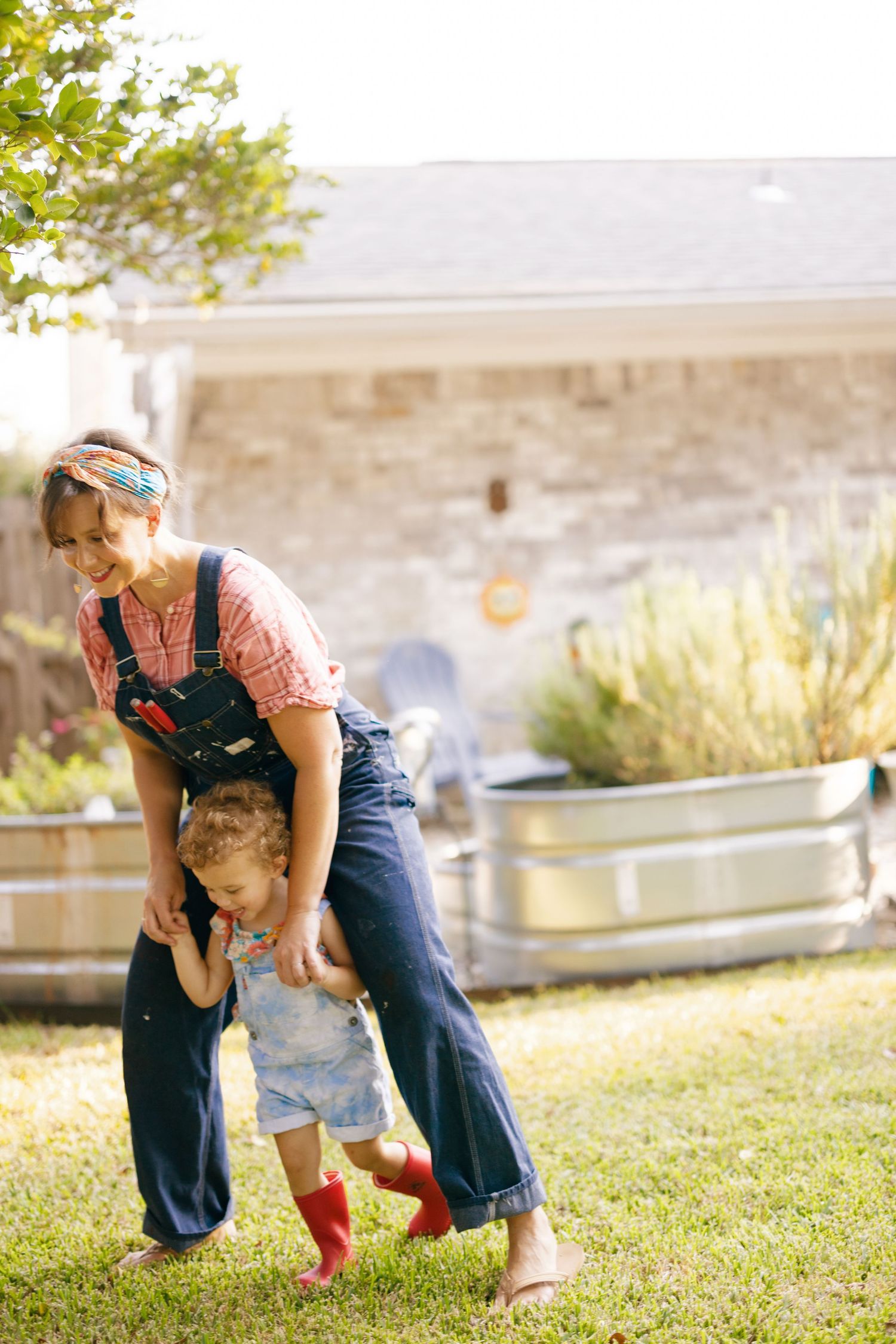 Joyful outdoor playtime in a grassy backyard with casual summer clothing.
