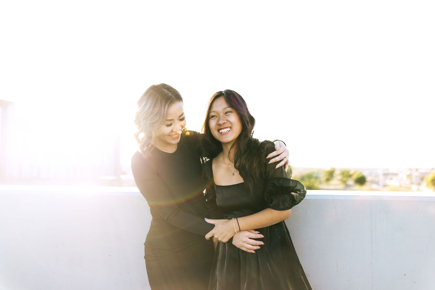 Happy couple embraces together while walking along a bright, sunny beachfront path.