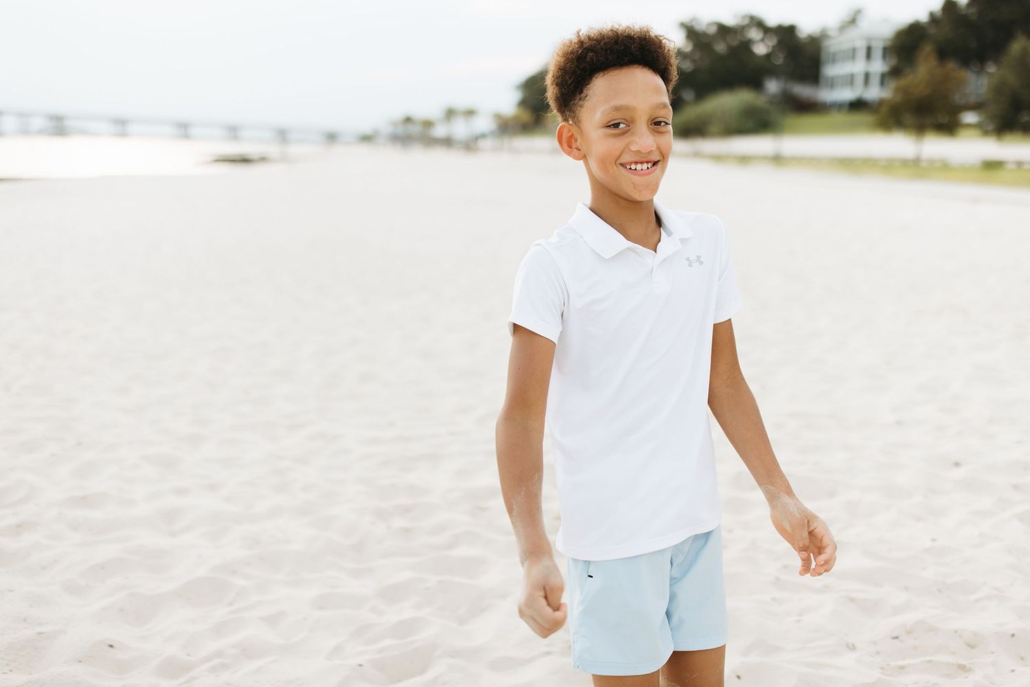 Children running and playing together on a bright sandy beach.