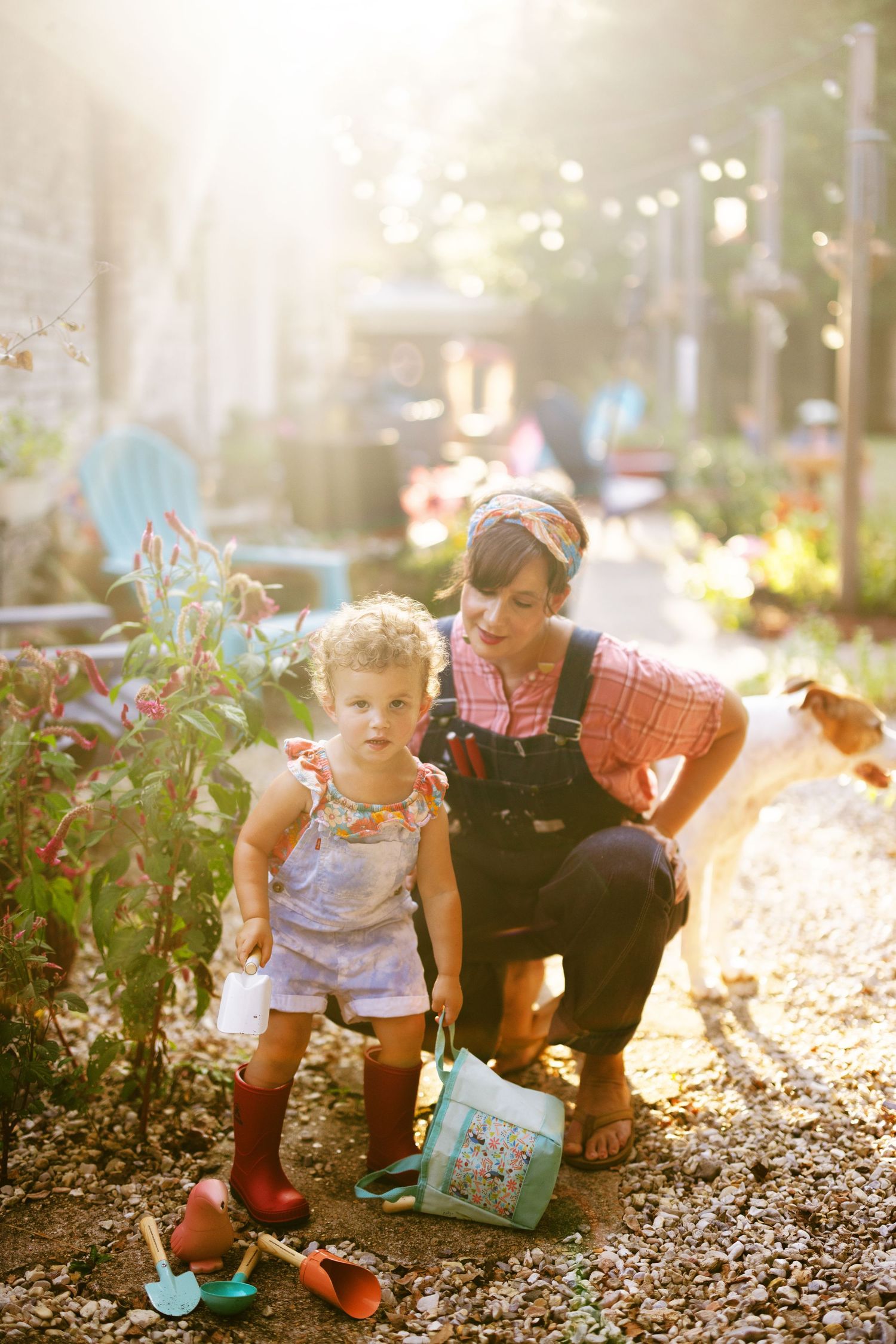 Sunlit garden scene showing gardening activities with plants and mulch on a warm afternoon.