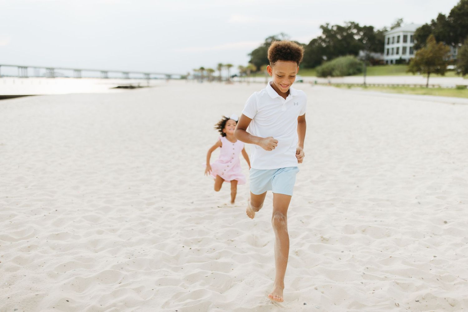 Candid moments of people playing and running in the soft sand at a beautiful beach.