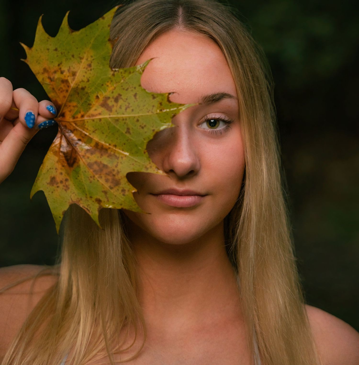 Series of photos showing someone playfully holding fall maple leaves in front of their face at different angles.