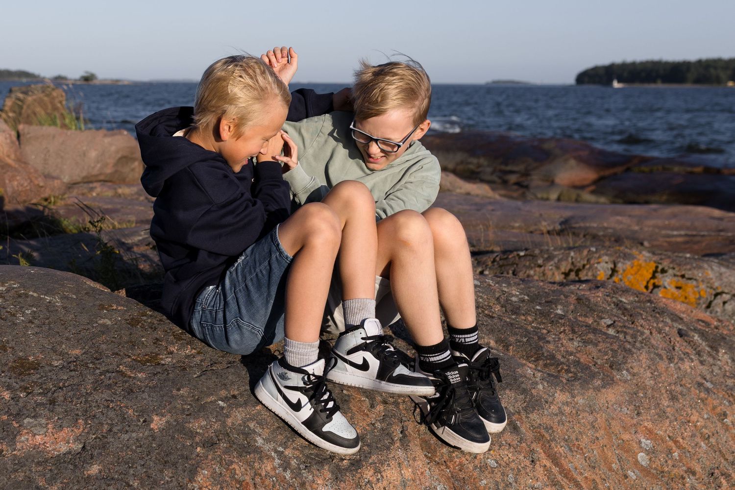 sisarukset nahistelevat kalliolla, lapsikuvaus miljöössä