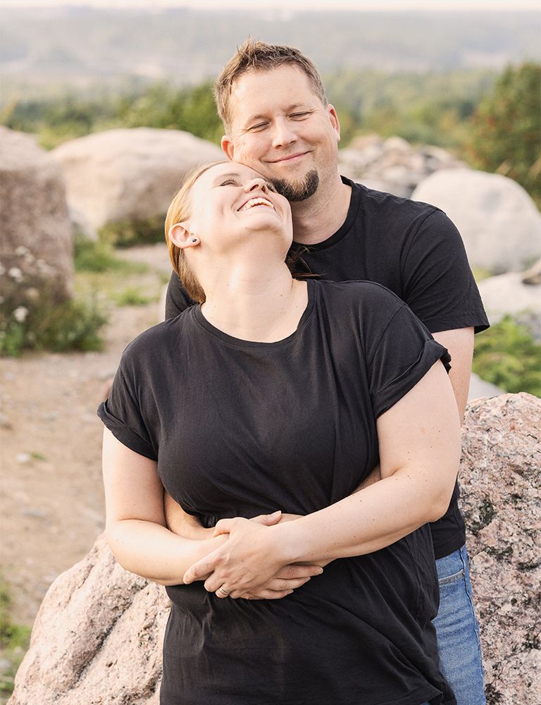 iloinen nainen ja mies halaavat toisiaan- parikuvaus miljöössä