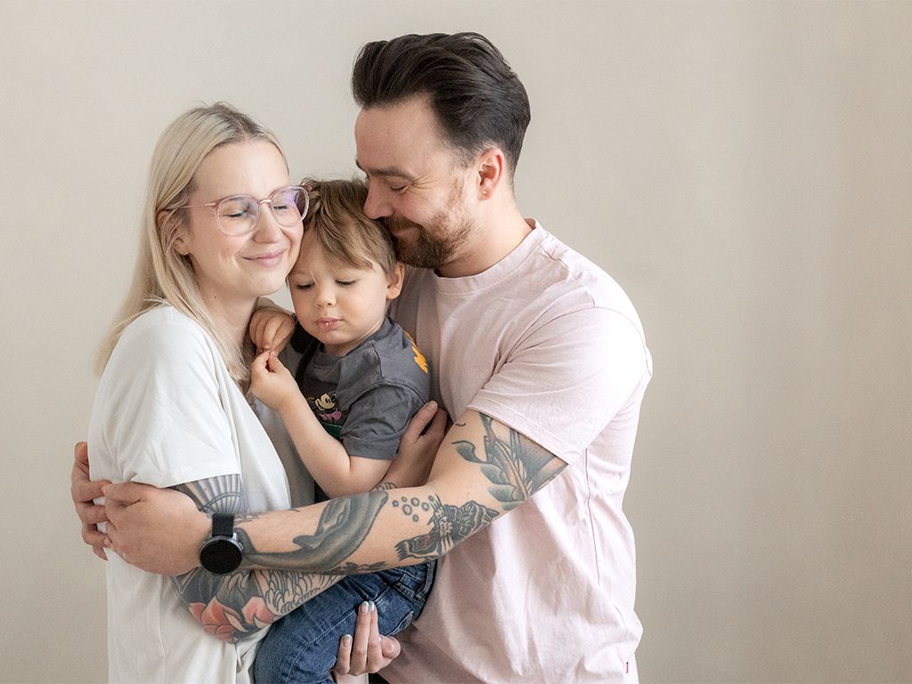 Äiti ja isä halaa lasta- perhekuvaus Helsinki
