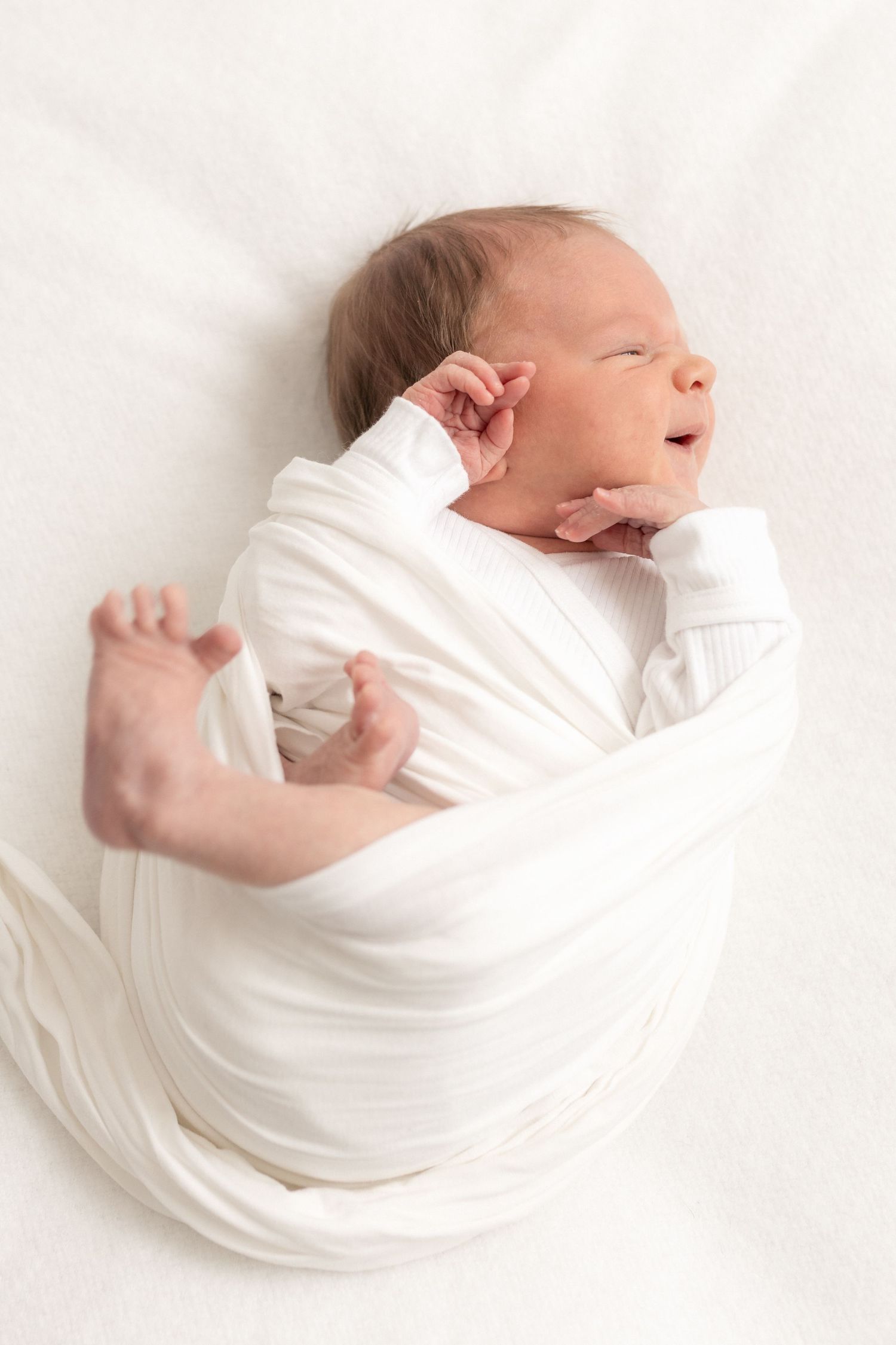 Nukkuva valkoiseen liinaan kapaloitu vastasyntynyt - newborn kuvaus