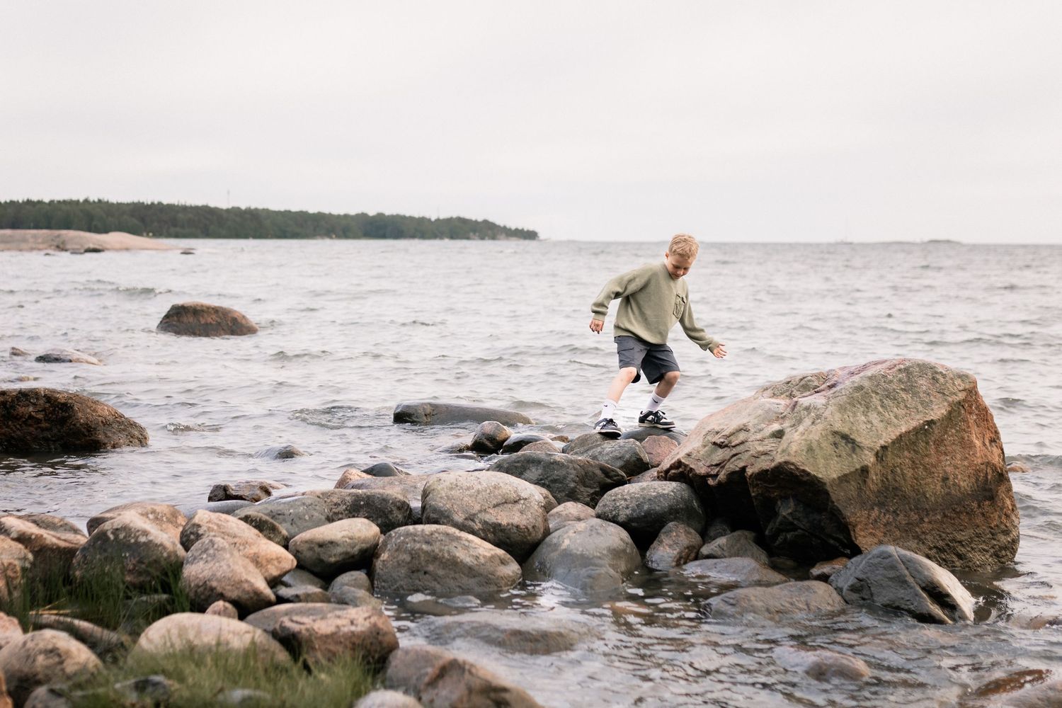 poika hyppii kivillä, lapsikuvaus miljöössä