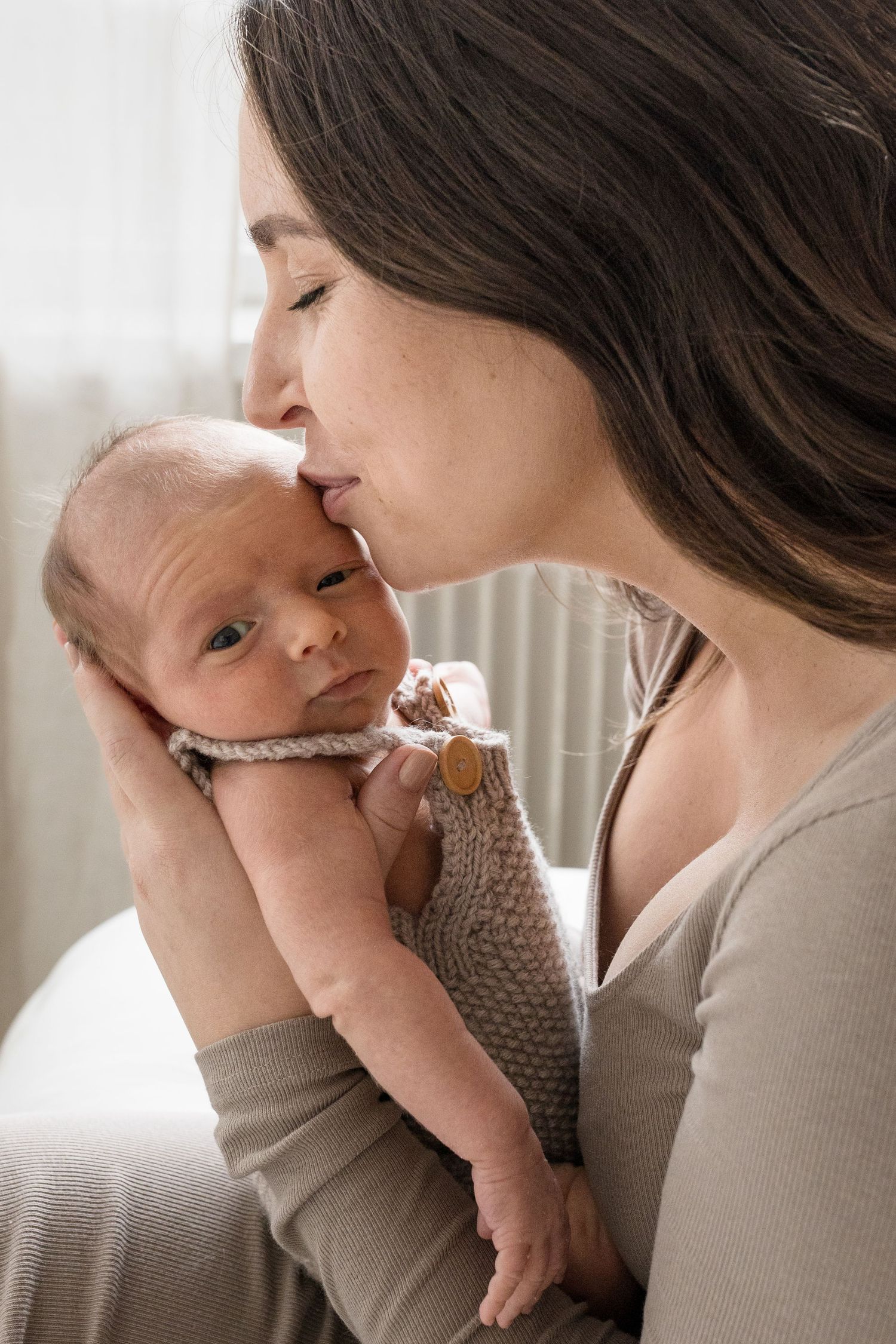 äiti pussaa vauvan otsaa, newborn kuvaus
