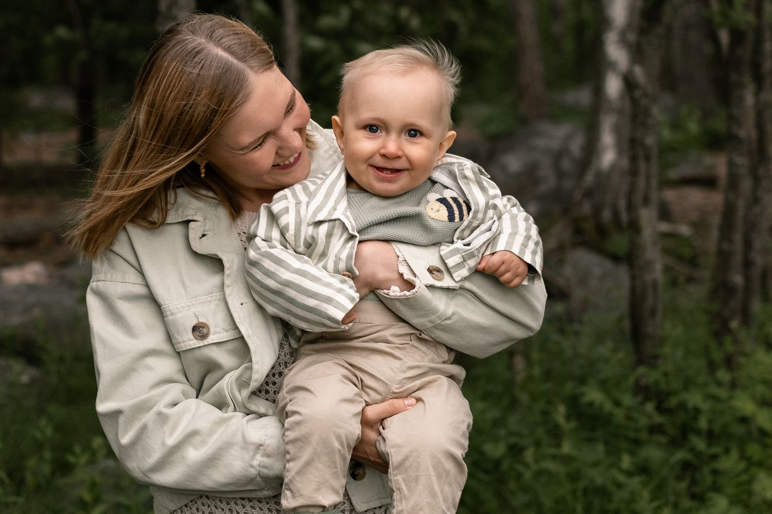 Iloinen lapsi äidin sylissä, perhekuvaus