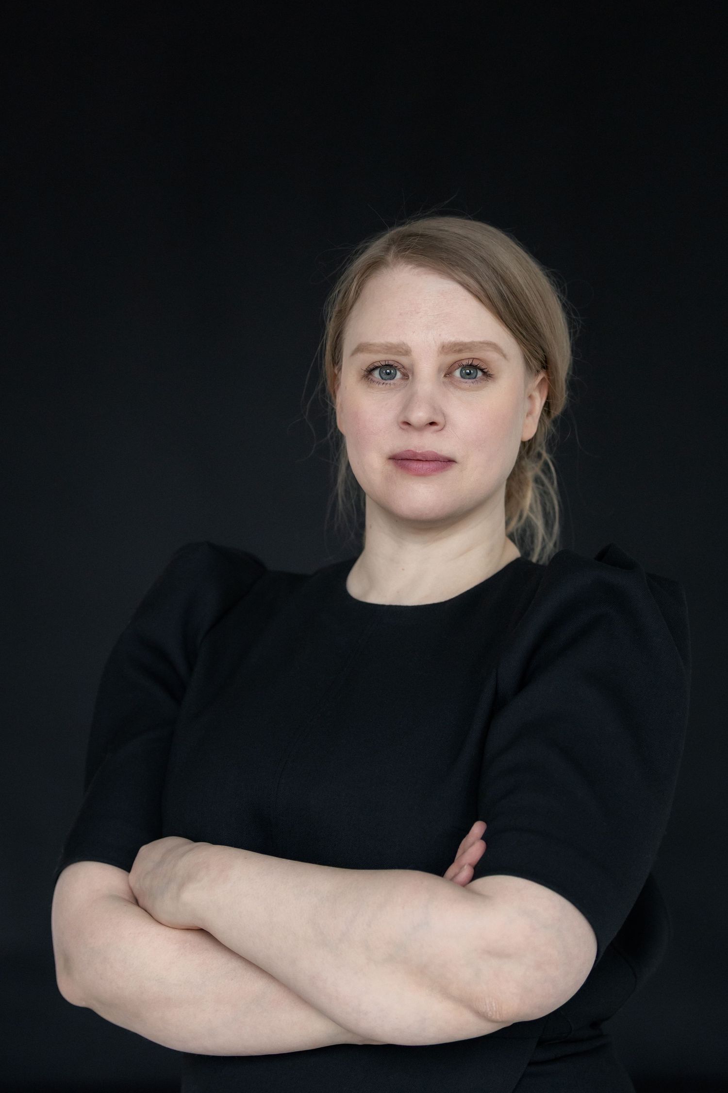 nainen mustassa paidassa, mustalla taustalla, henkilökuvaus