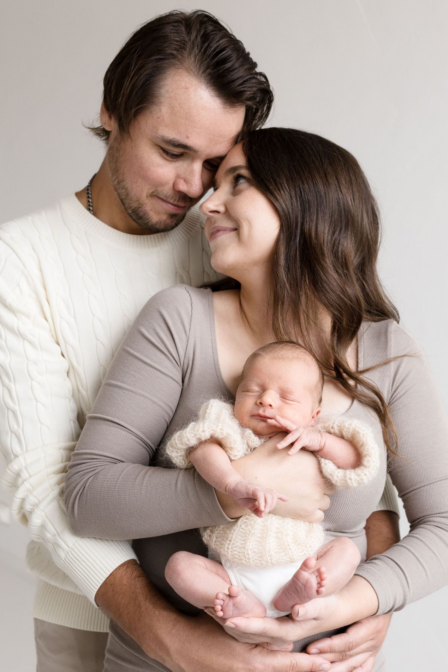 Ylpeät vanhemmat vastasyntynyt sylissään, newbornkuvaus